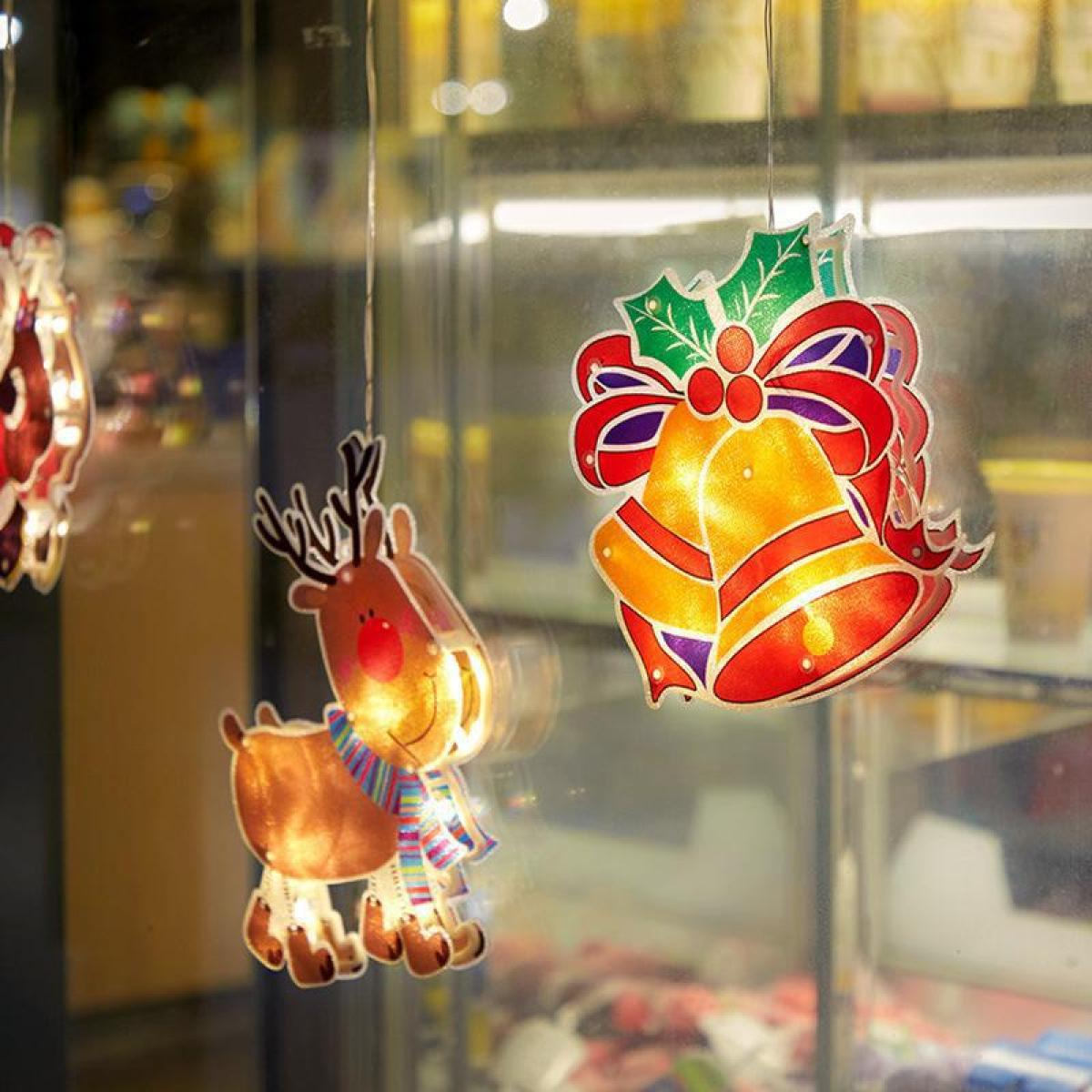 Fensterdekorationen: Rentier- und glockenförmige Lichter.