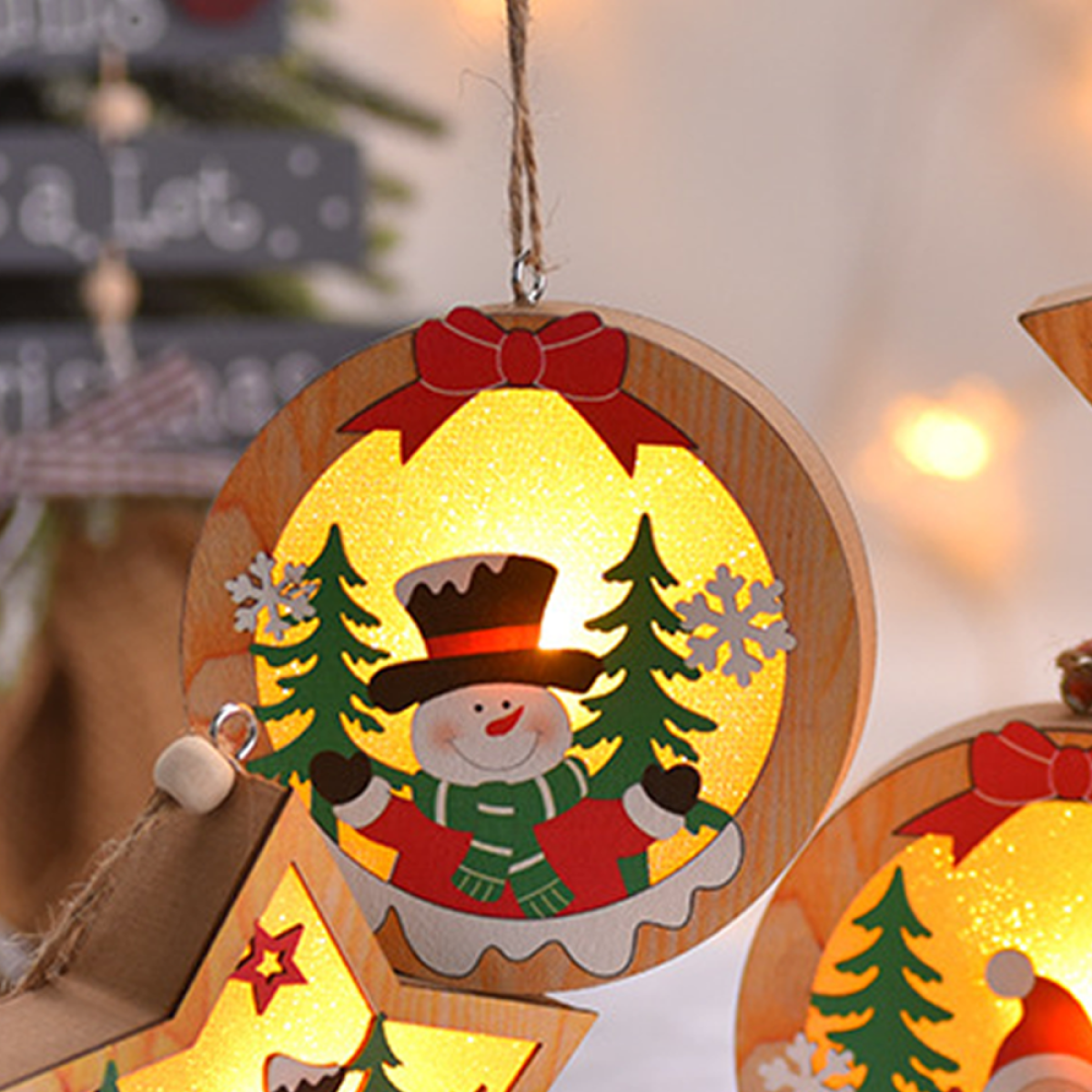 Nahaufnahme von Weihnachtsschmuck. Holzige kreisförmige Dekorationen mit Schneemann und Bäumen, die innen leuchten.