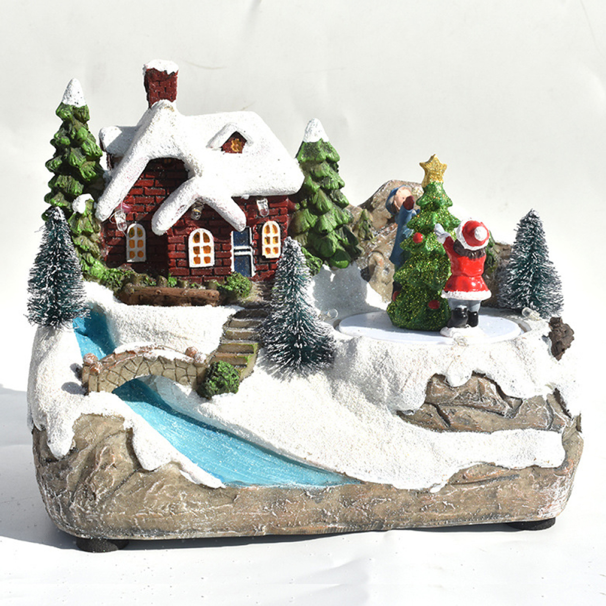 Eine weihnachtliche Szene mit einem Haus, einem Baum und einer Figur in roter Kleidung im Schnee.