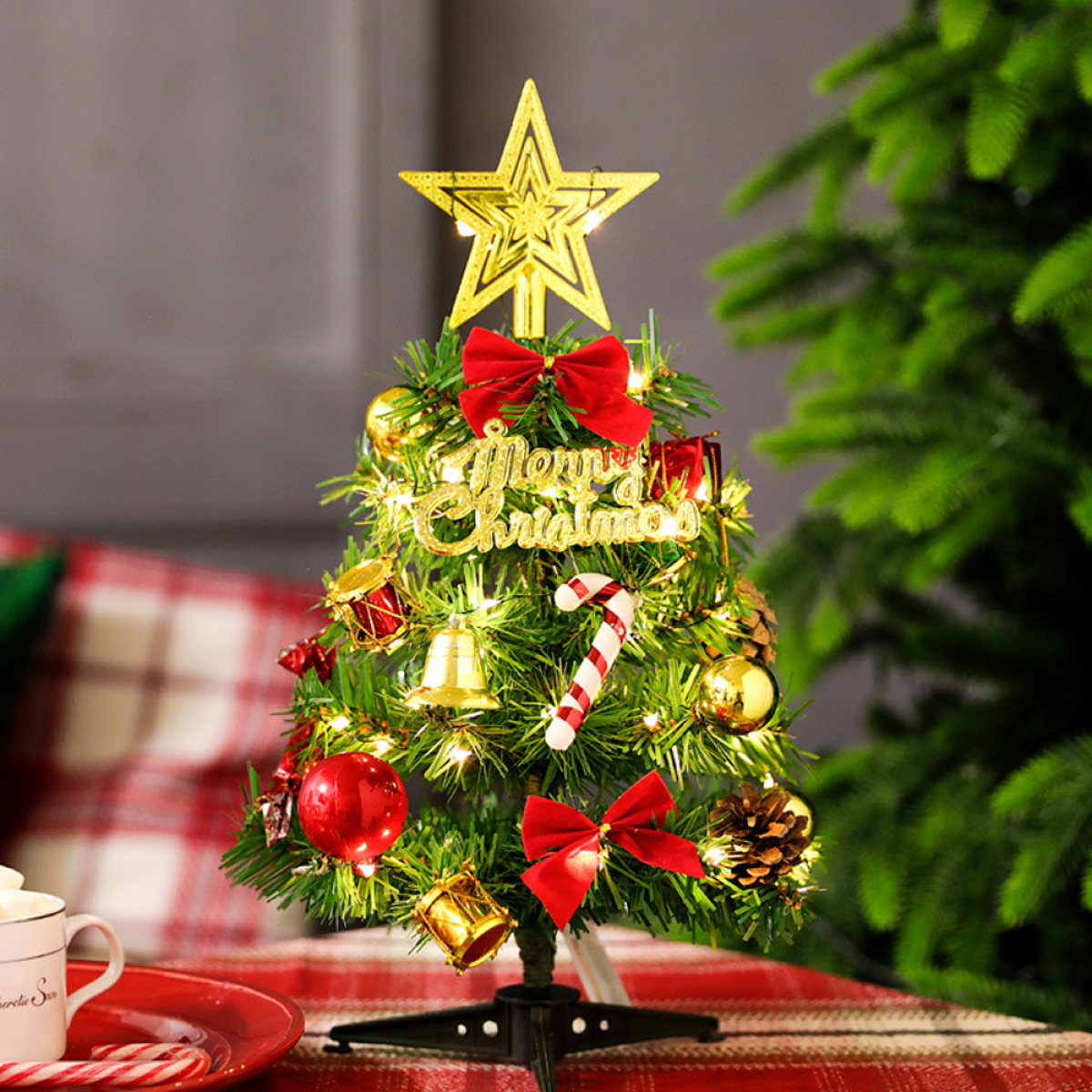 Ein kleiner Weihnachtsbaum, geschmückt mit Ornamenten und Lichtern, mit einem Stern oben.
