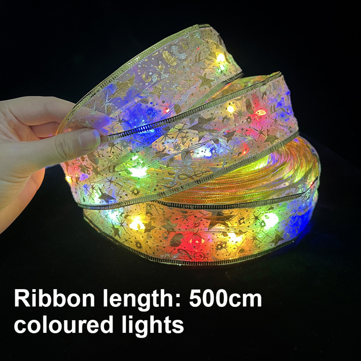 Eine Rolle Band mit eingebetteten mehrfarbigen Lichtern, gehalten von einer Hand, auf dunklem Hintergrund.
