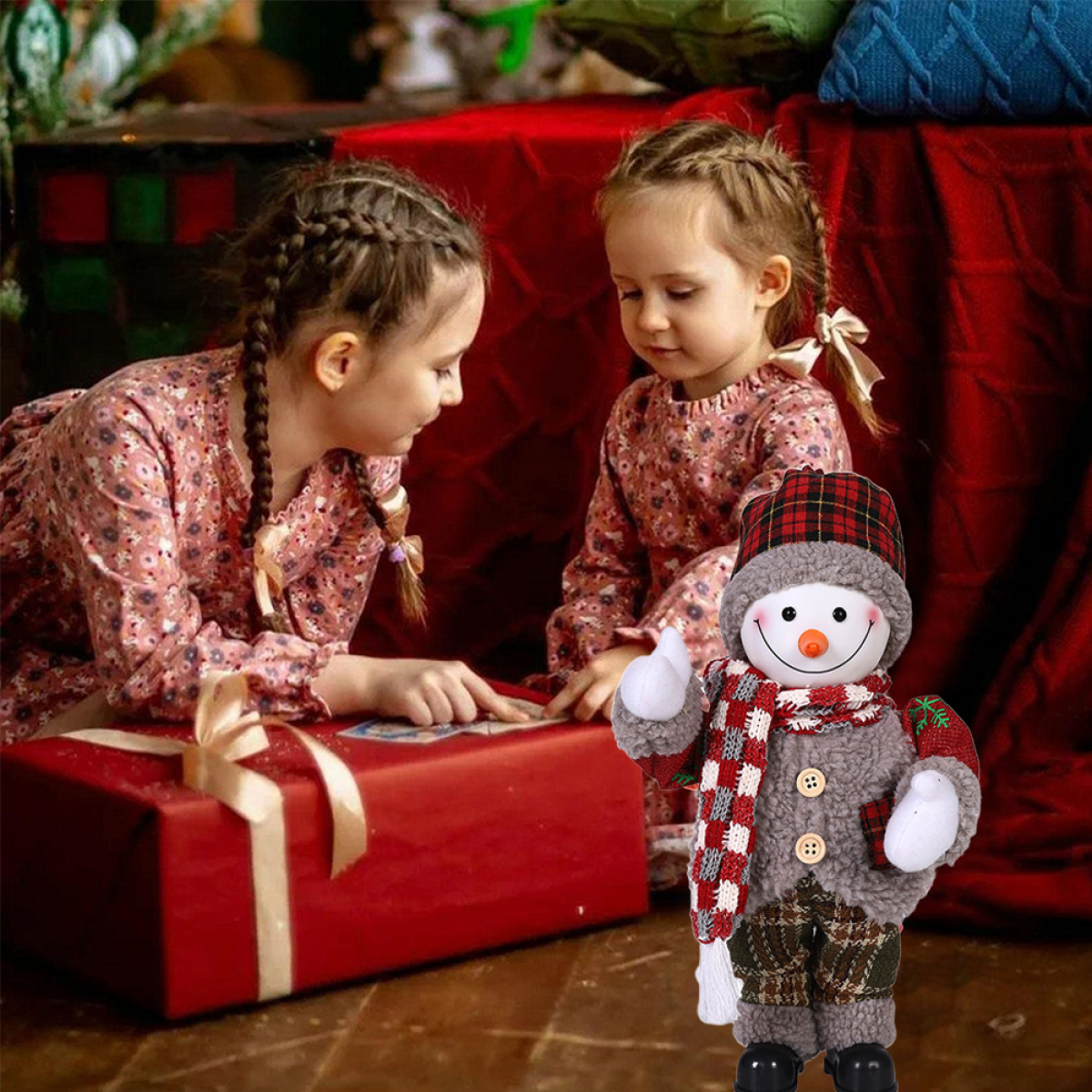 Zwei Mädchen betrachten ein Geschenk mit einem Schneemann, rote Geschenkbox.