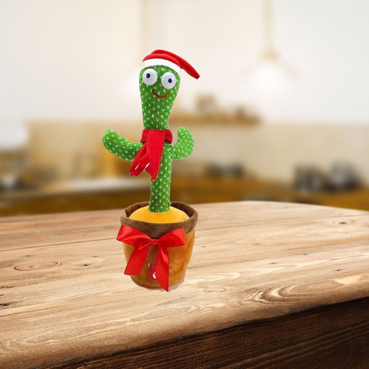 Lachendes Kaktusspielzeug mit Weihnachtsmütze und Schal in einem braunen Topf auf Holztisch.