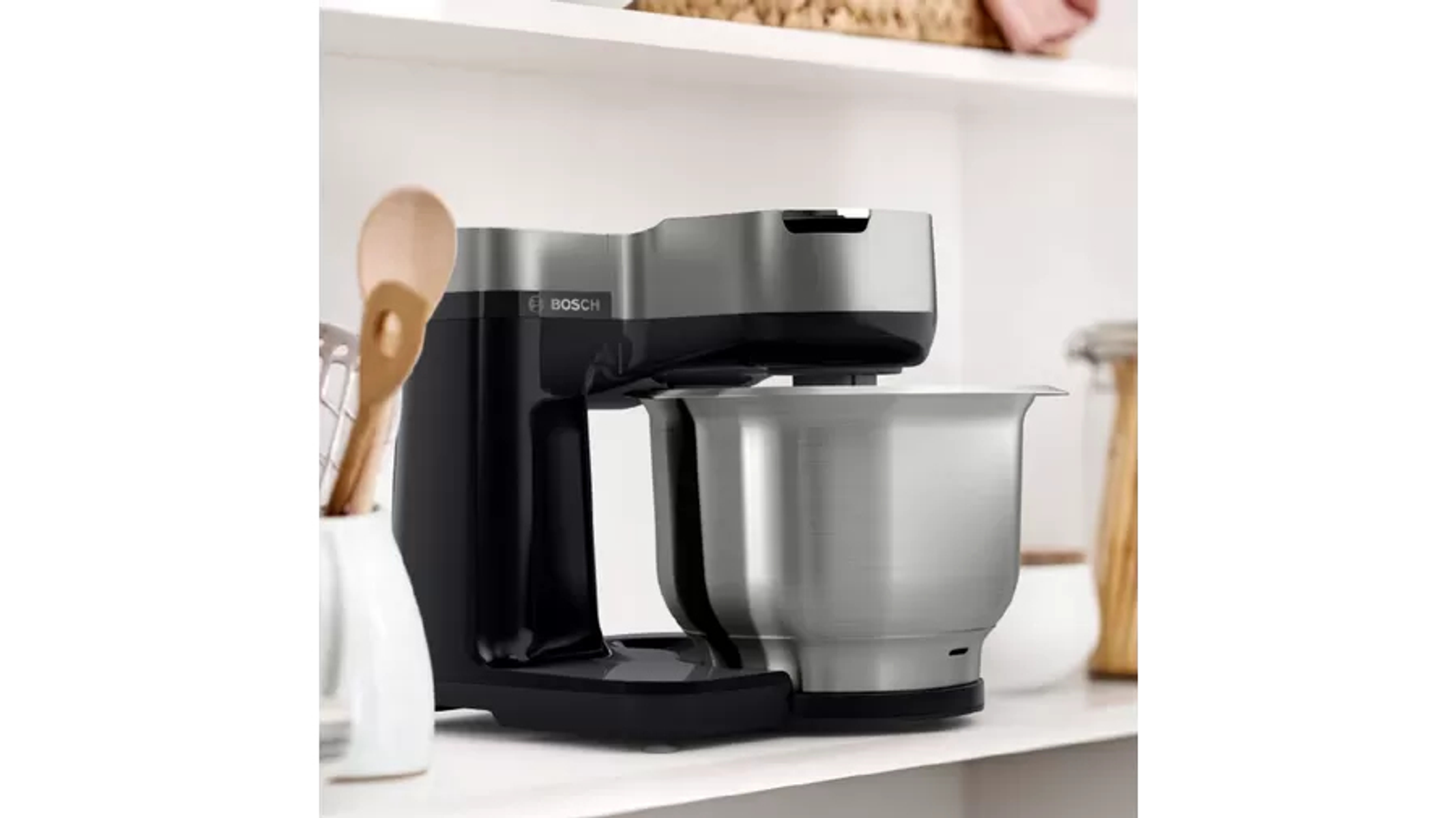 Electrodoméstico de cocina, tazón de acero inoxidable y base negra. Estantes y otras herramientas.