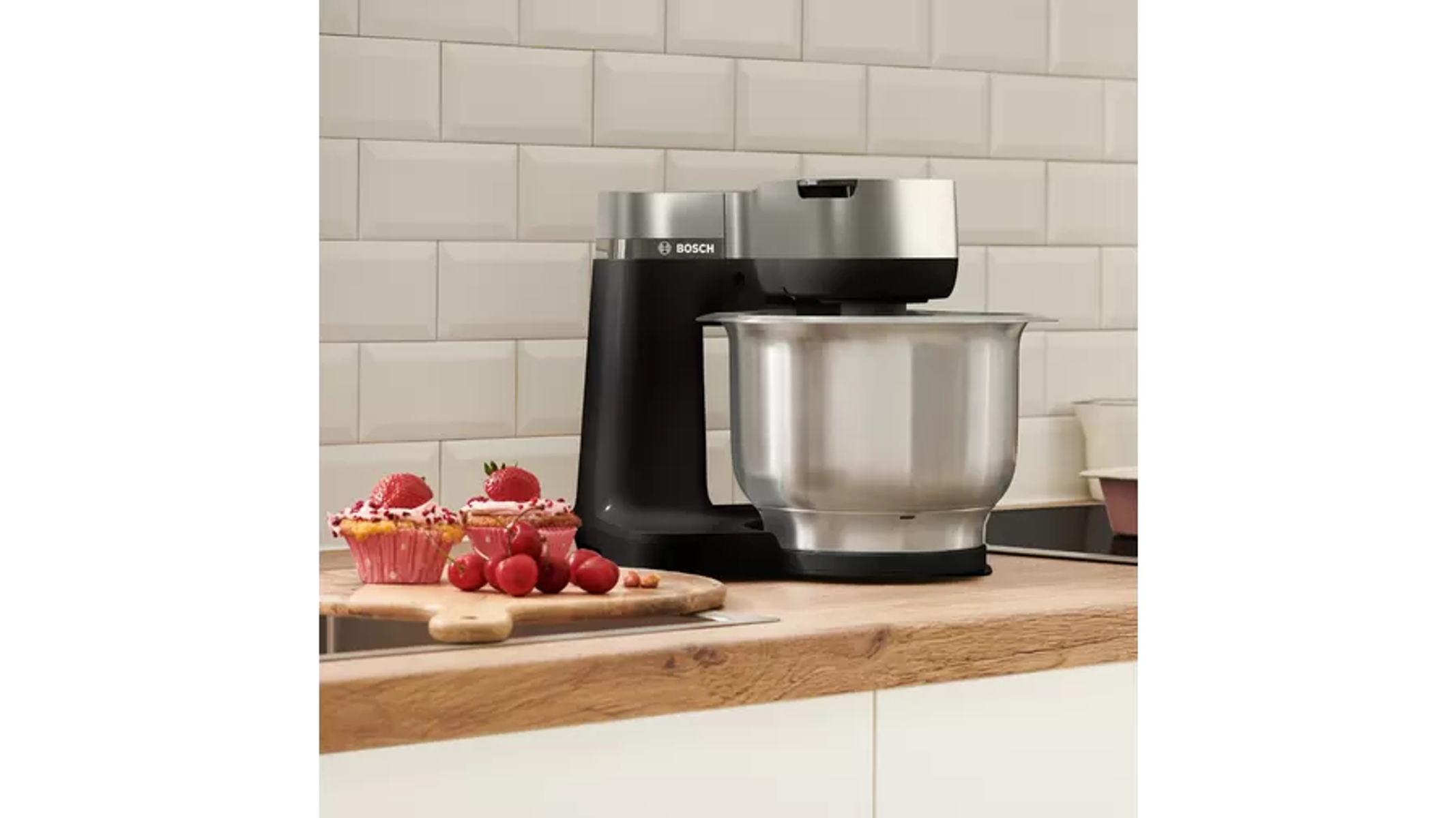 Electrodoméstico de cocina, batidora de pie de acero inoxidable con cupcakes, fresas y cerezas.