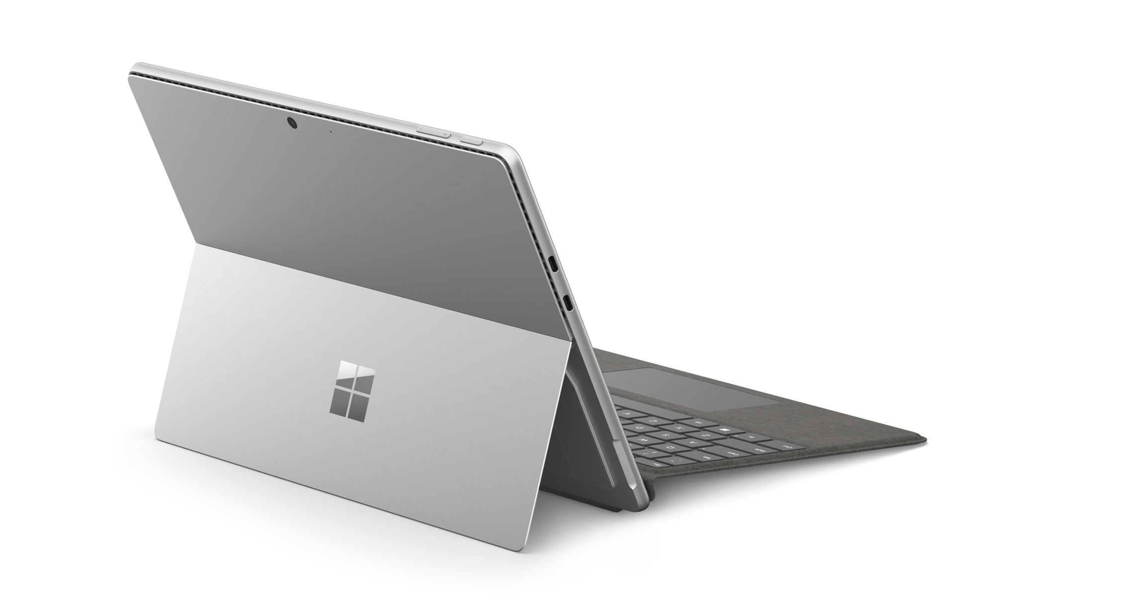 Tablet Microsoft Surface argentato parzialmente aperto su sfondo nero con macchie bianche.