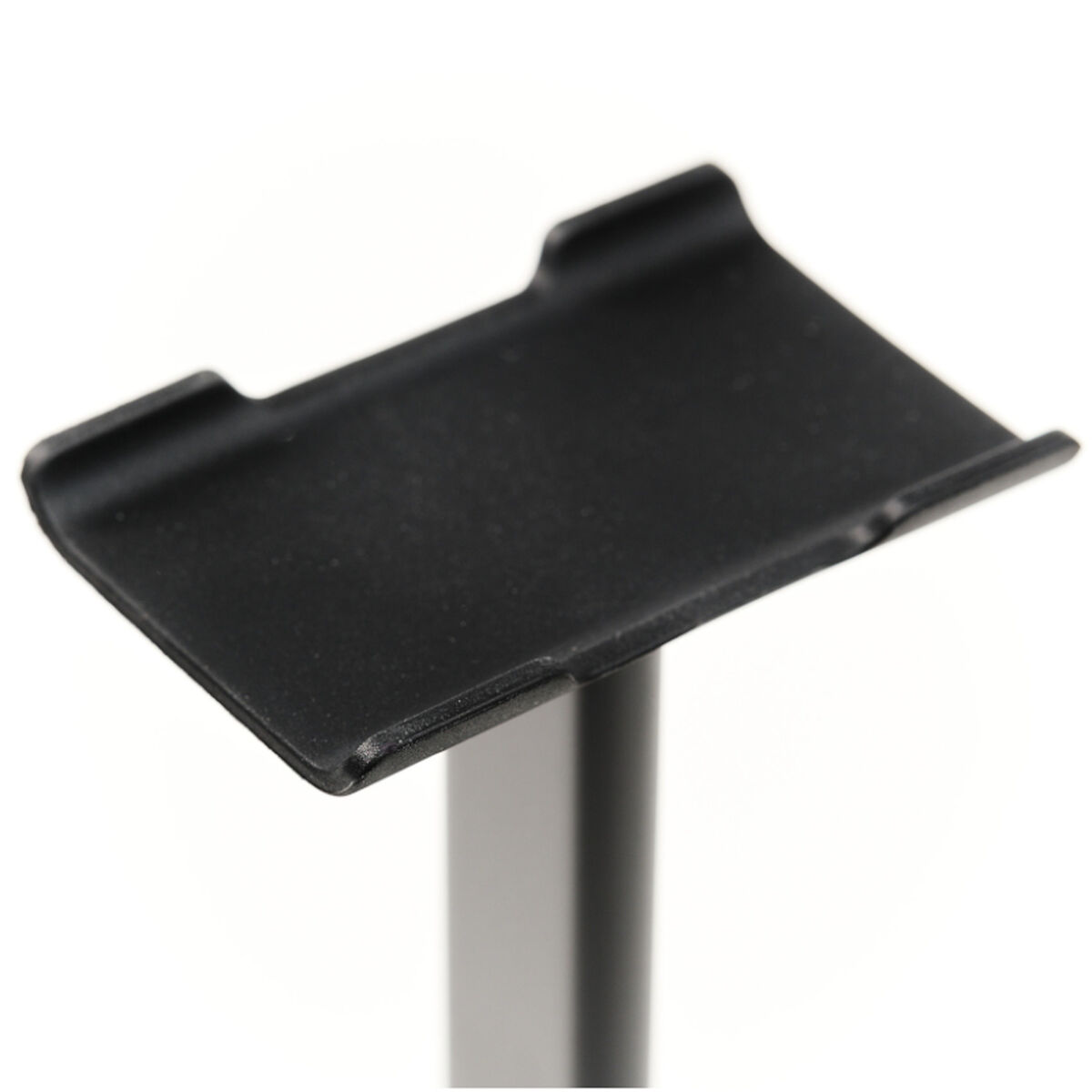 Un soporte negro para dispositivos, inclinado hacia arriba, sobre un fondo blanco.