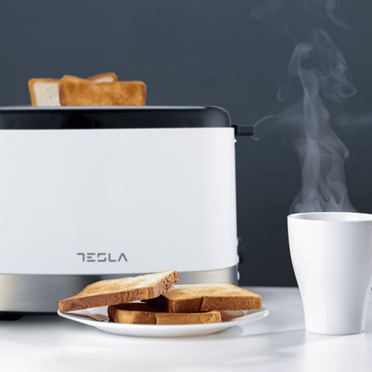 Biały toster z tostami na talerzu i na górze. Para unosi się z białego kubka.