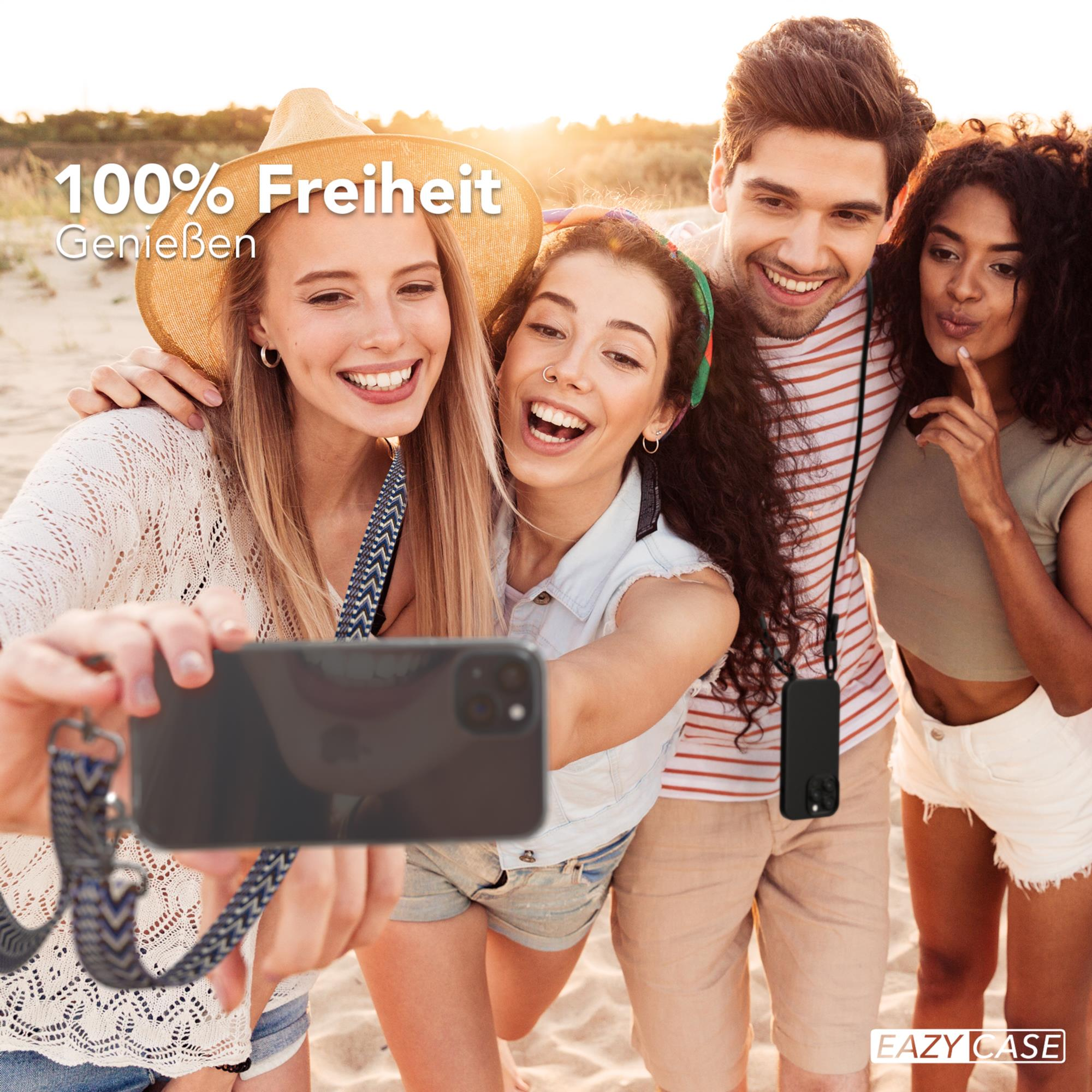 Vier Personen machen ein Selfie am Strand und lächeln.