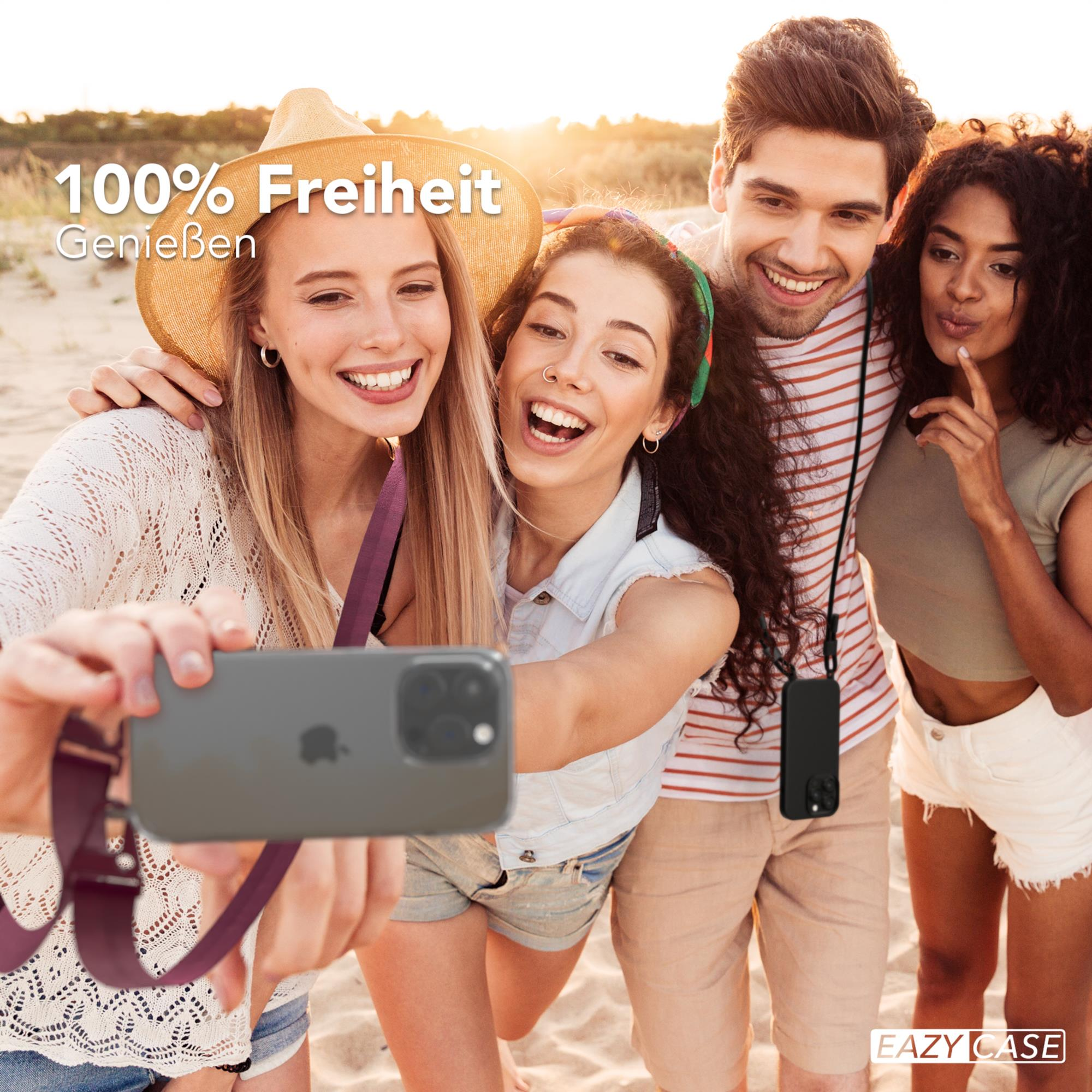 Vier Freunde machen ein Selfie am Strand; einer hält das Telefon mit Hülle, lächelnd.