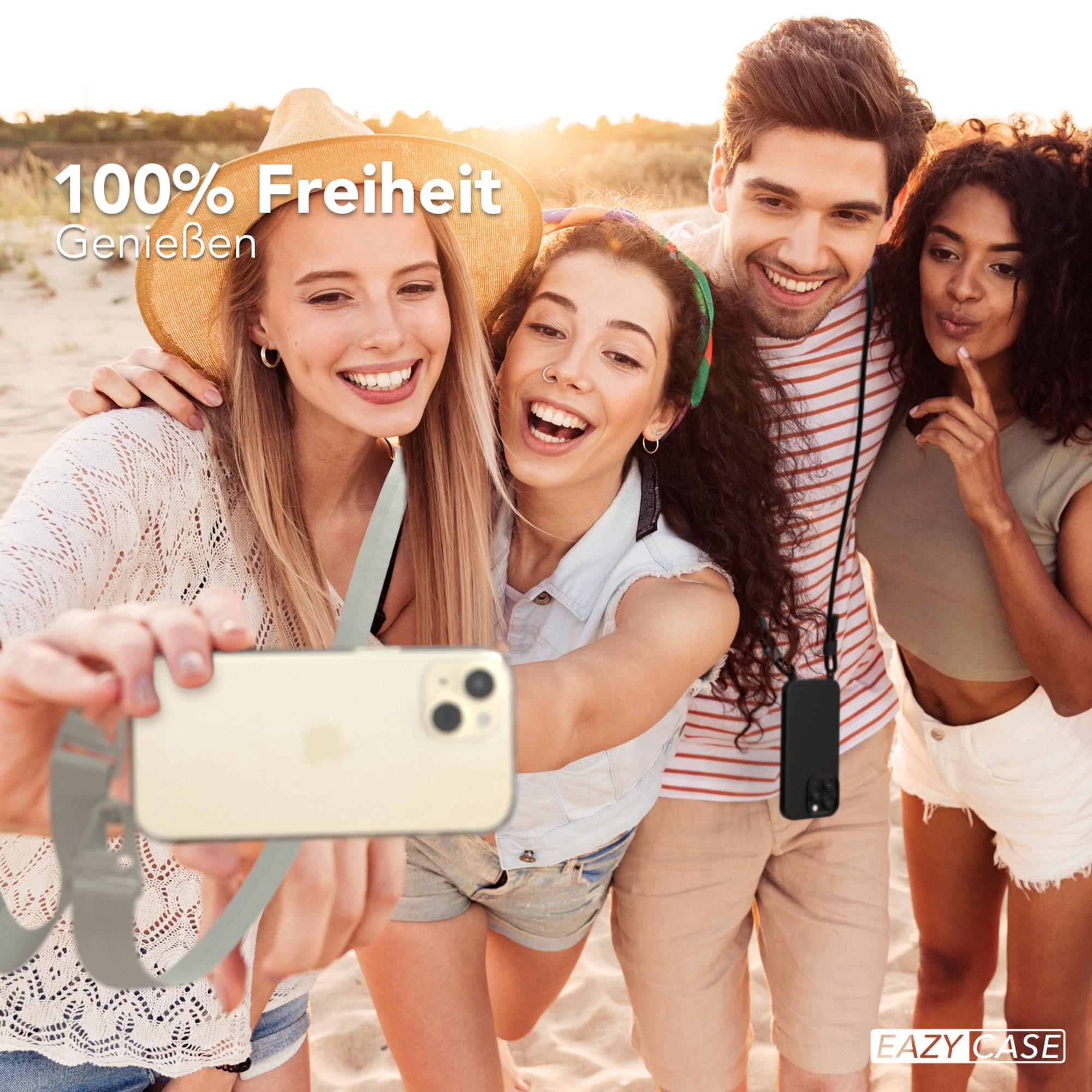 Vier Personen machen ein Selfie am Strand, eine Person hält ein Telefon.