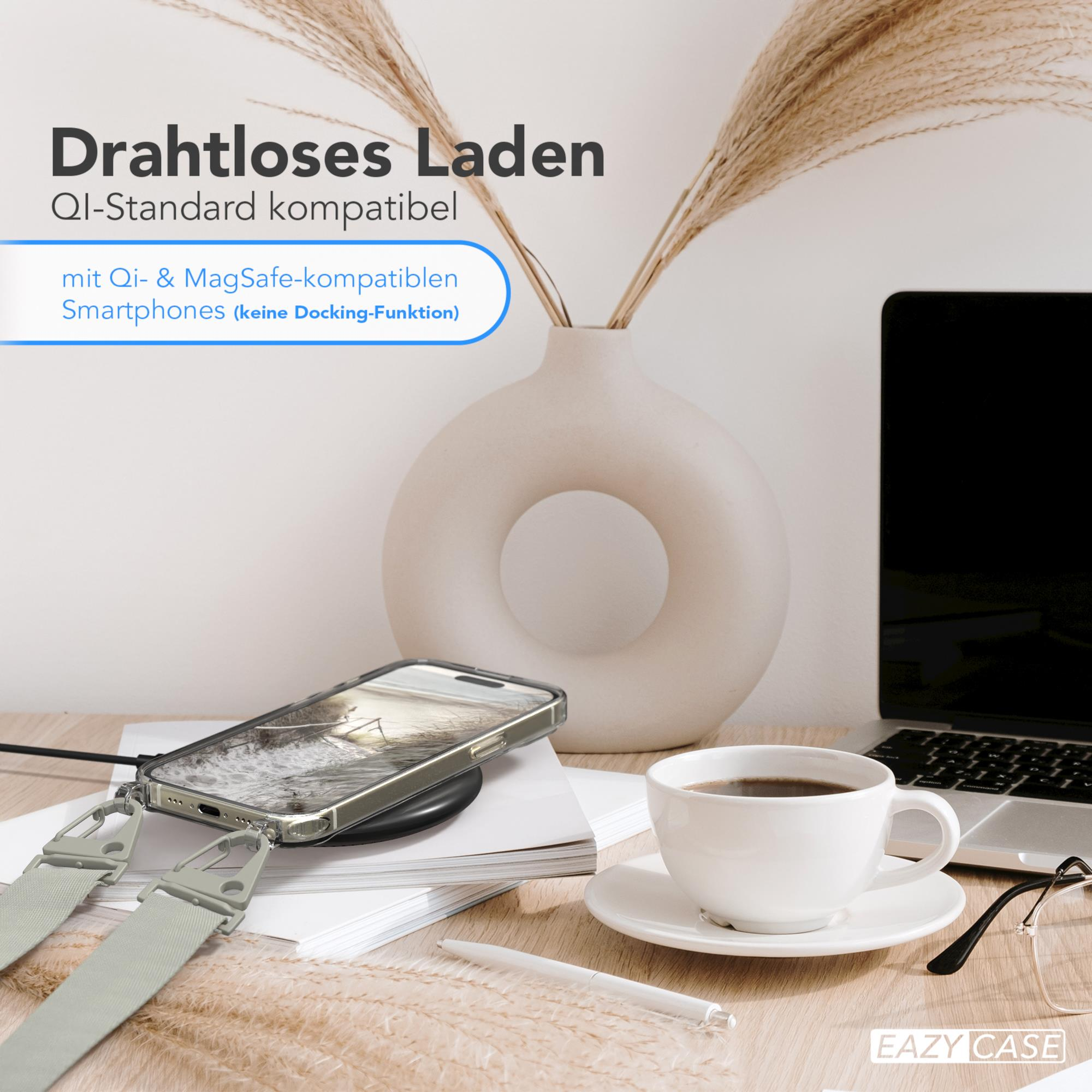 Ein Telefon auf einem kabellosen Ladegerät, eine Tasse und ein Laptop.