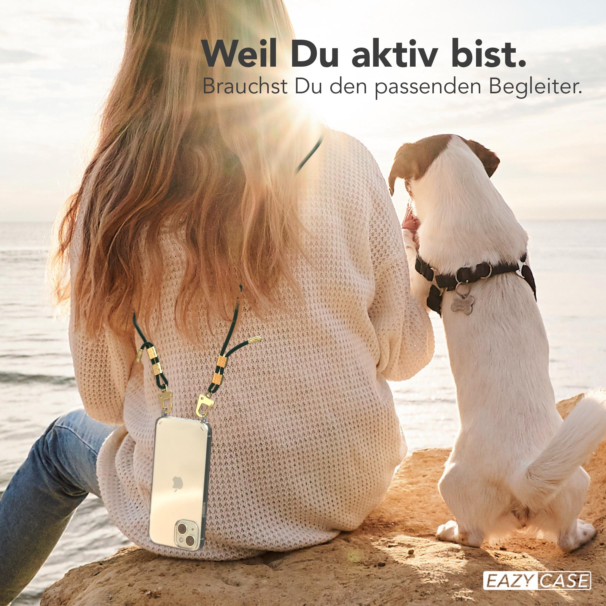 Frau mit Handyhülle am Strand. Hund steht neben ihr.
