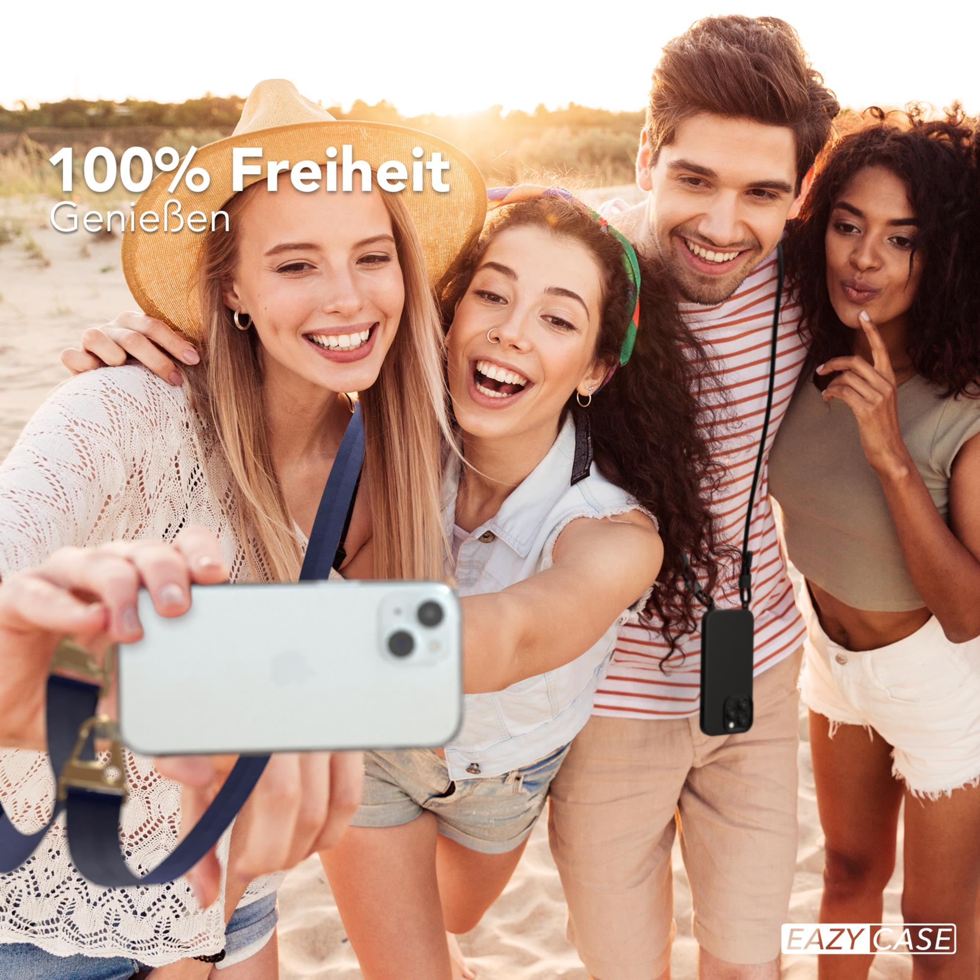 Eine Gruppe von vier Personen macht ein Selfie am Strand und lächelt.
