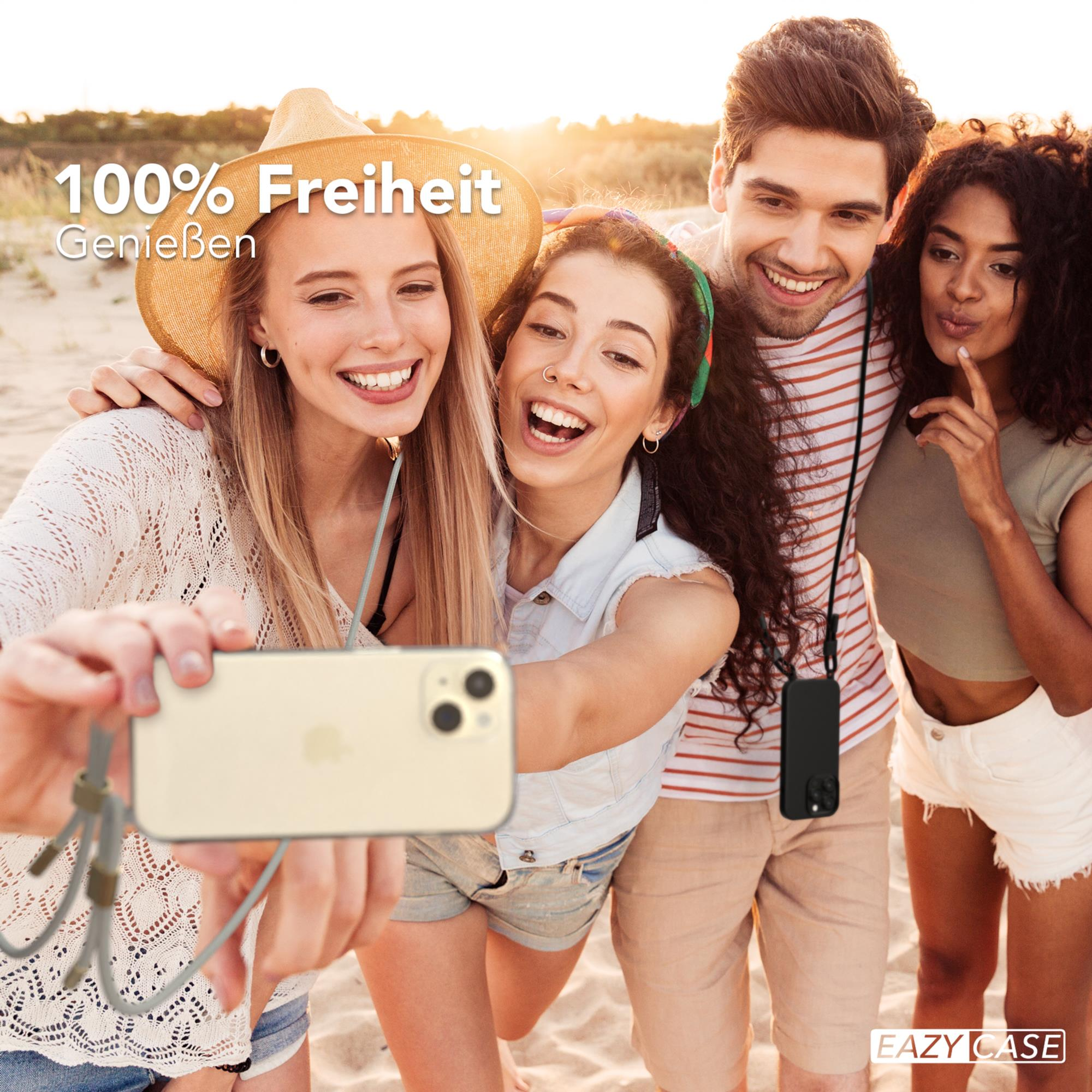 Vier Freunde machen ein Selfie am Strand. Sie lächeln und halten ein Telefon.