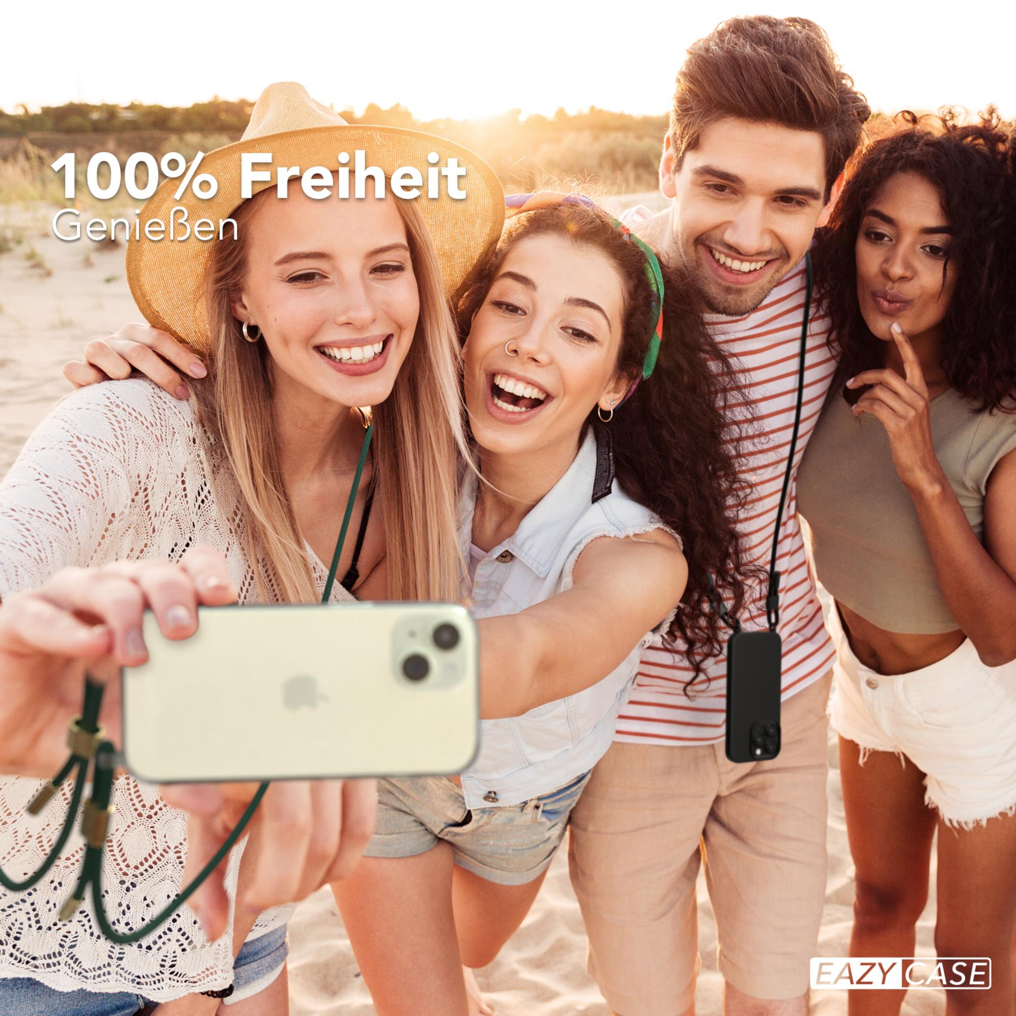 Vier Personen machen ein Selfie am Strand, lächeln und halten ein Telefon.