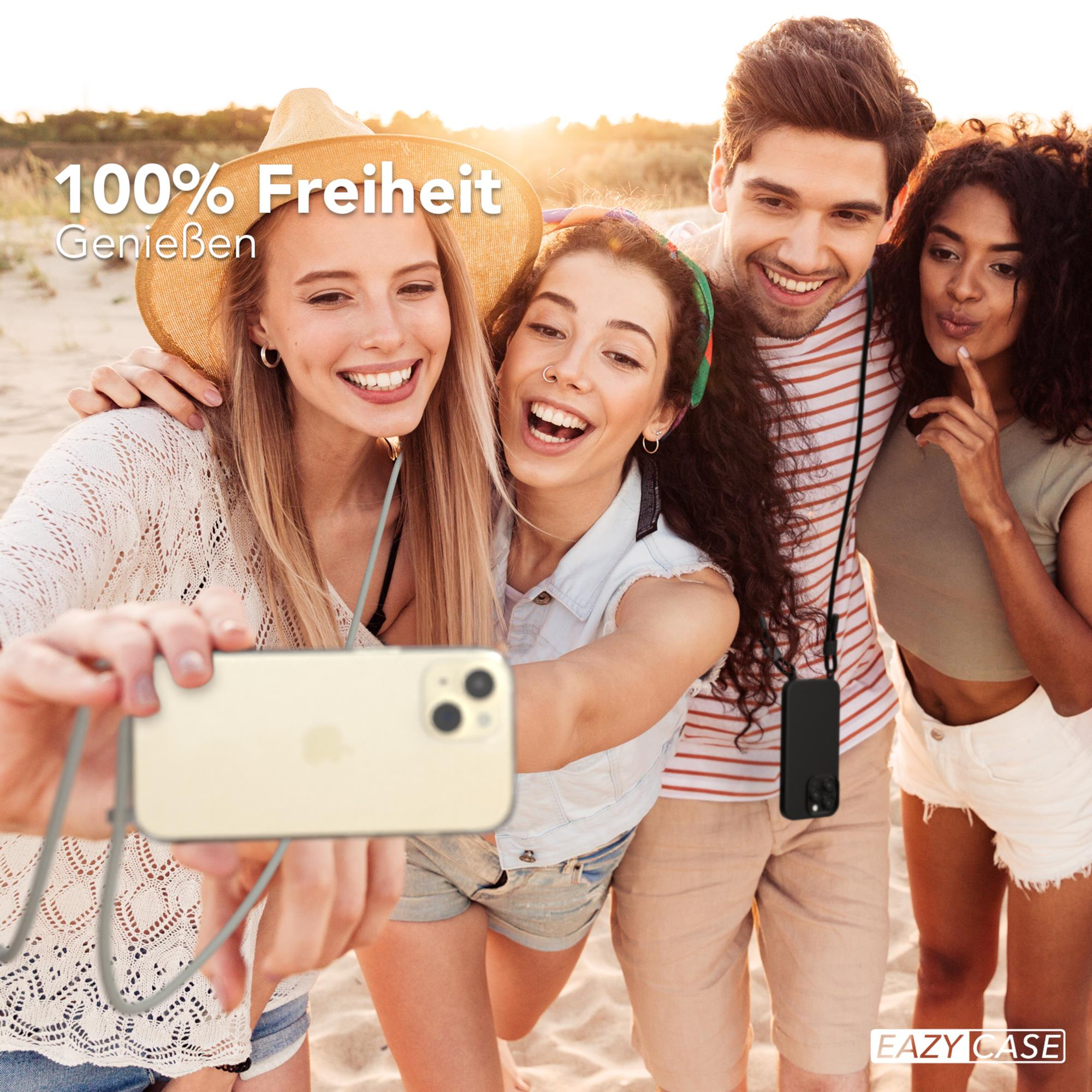 Freunde machen Selfie am Strand. Einer hält das Telefon mit einem Umhängeband.