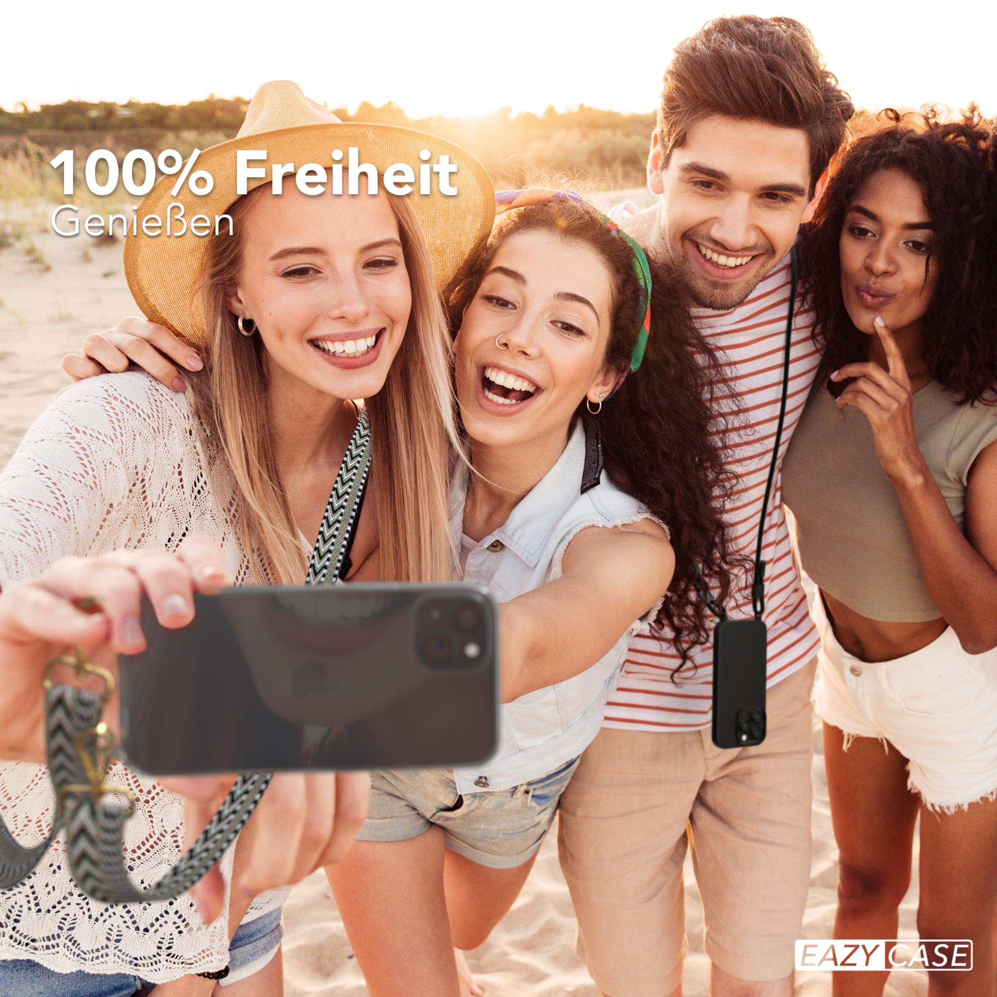 Vier Personen machen ein Selfie am Strand, lächeln, halten ein Telefon mit Hülle.