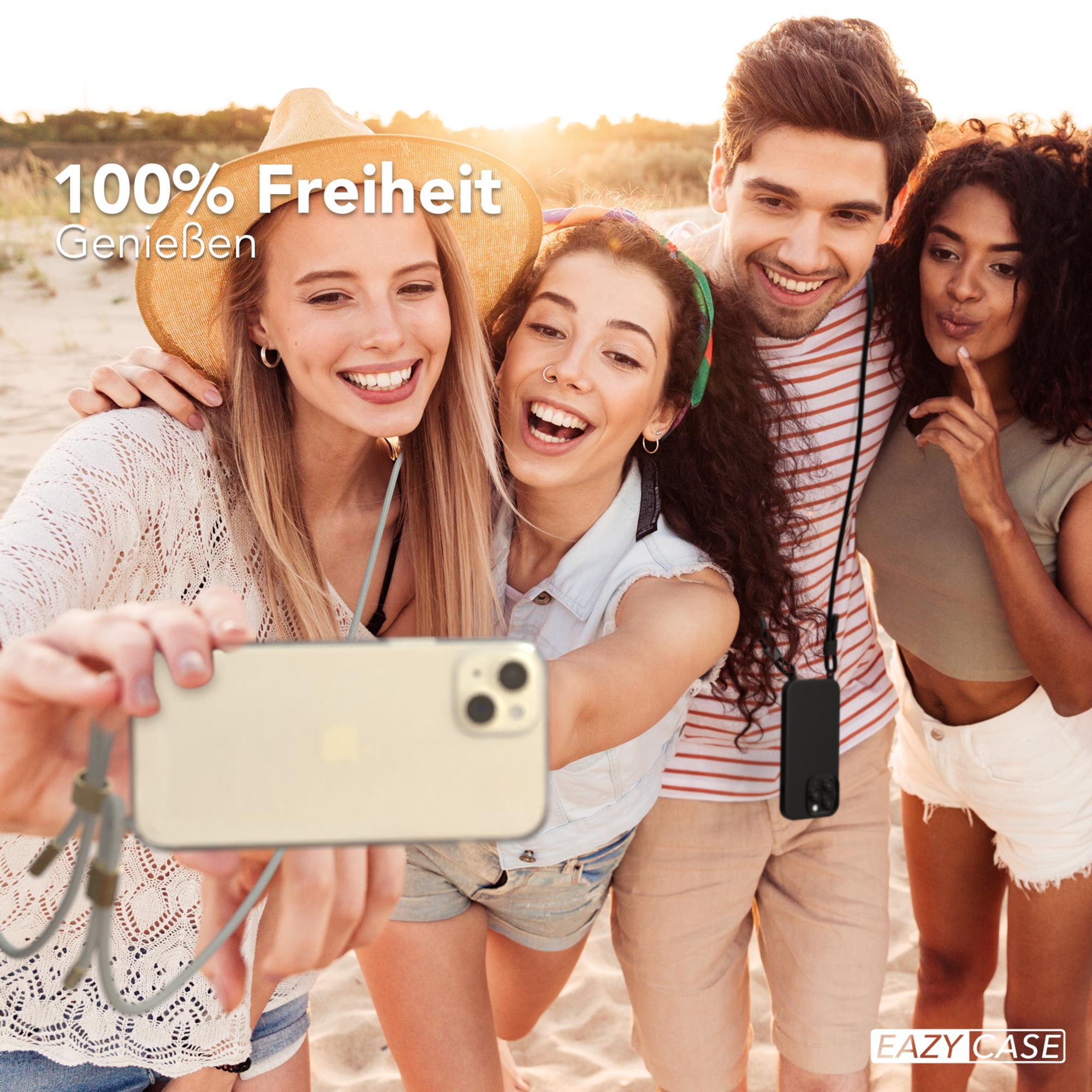Vier junge Leute machen ein Selfie am Strand, sonnenbeschienen mit einem Telefon mit Riemen.