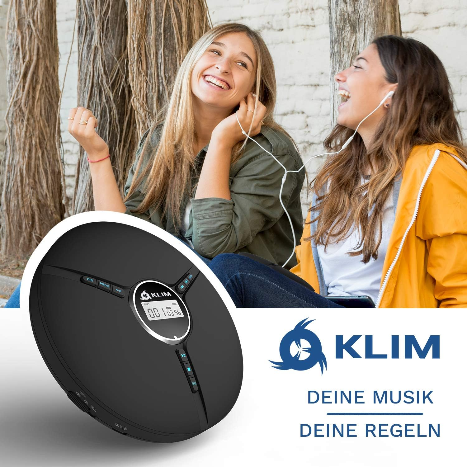 Zwei Frauen hören Musik mit einem schwarzen tragbaren CD-Player, lächeln und lachen.