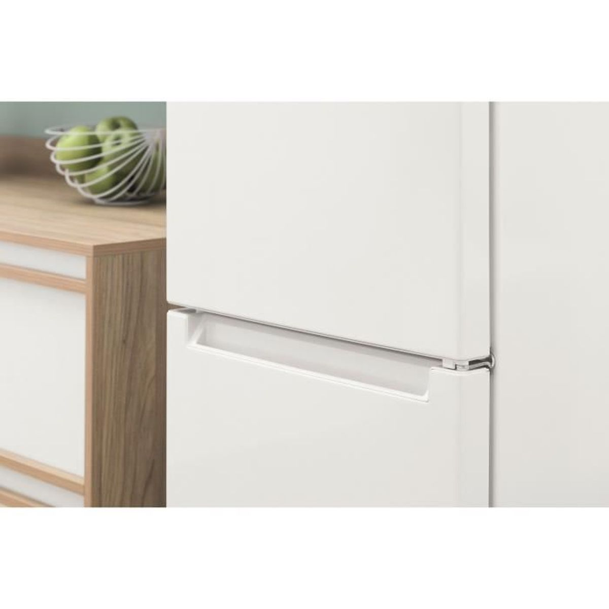 Primer plano de un refrigerador blanco. El mango es visible, con madera y una cesta de alambre en el fondo.