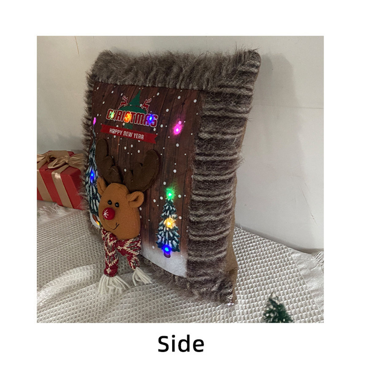 Weihnachtskissen mit Rentier, Weihnachtsbaum und Lichtern. Seitenansicht.