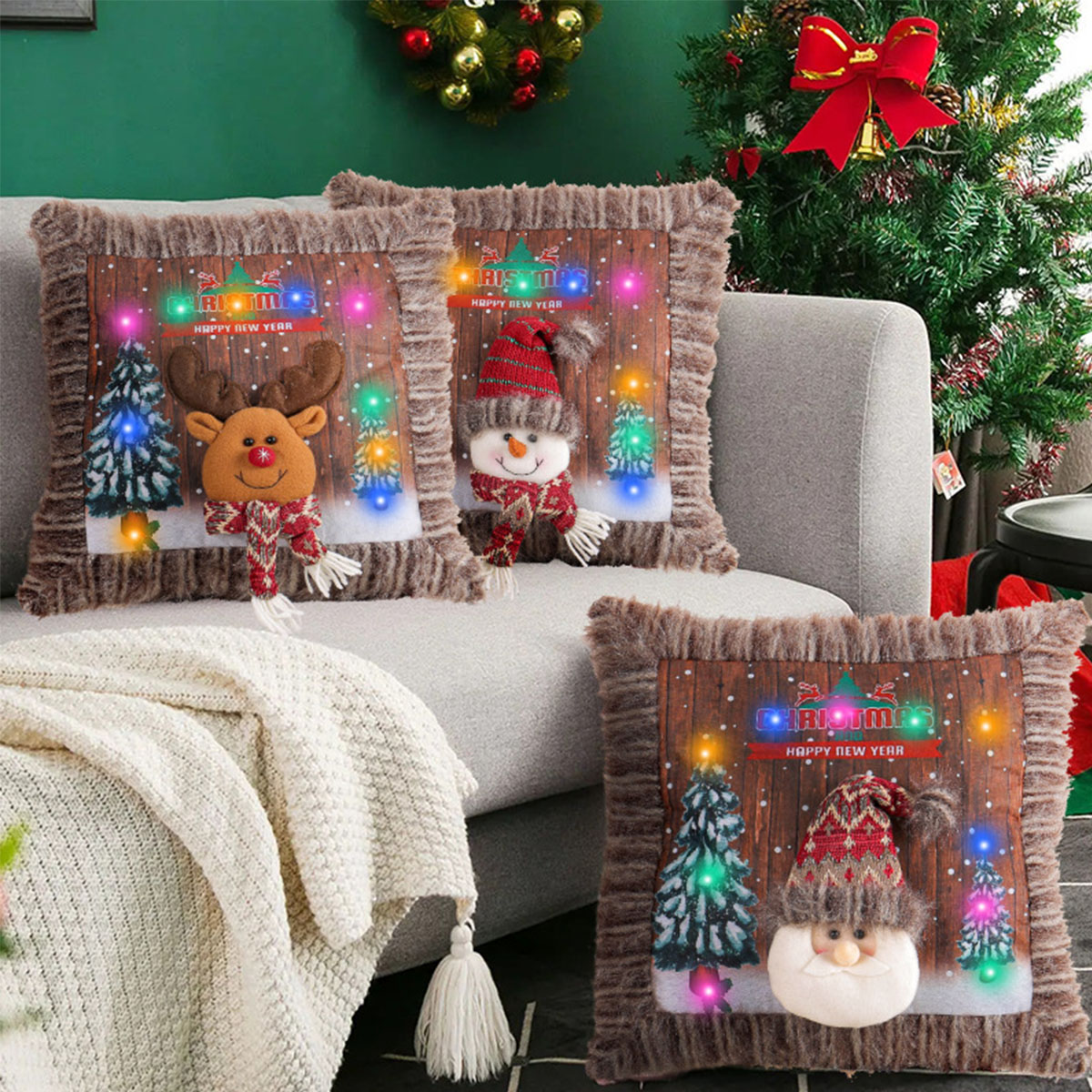 Weihnachtskissen auf einem grauen Sofa, mit Baum, Schneemann und Rentier-Design.