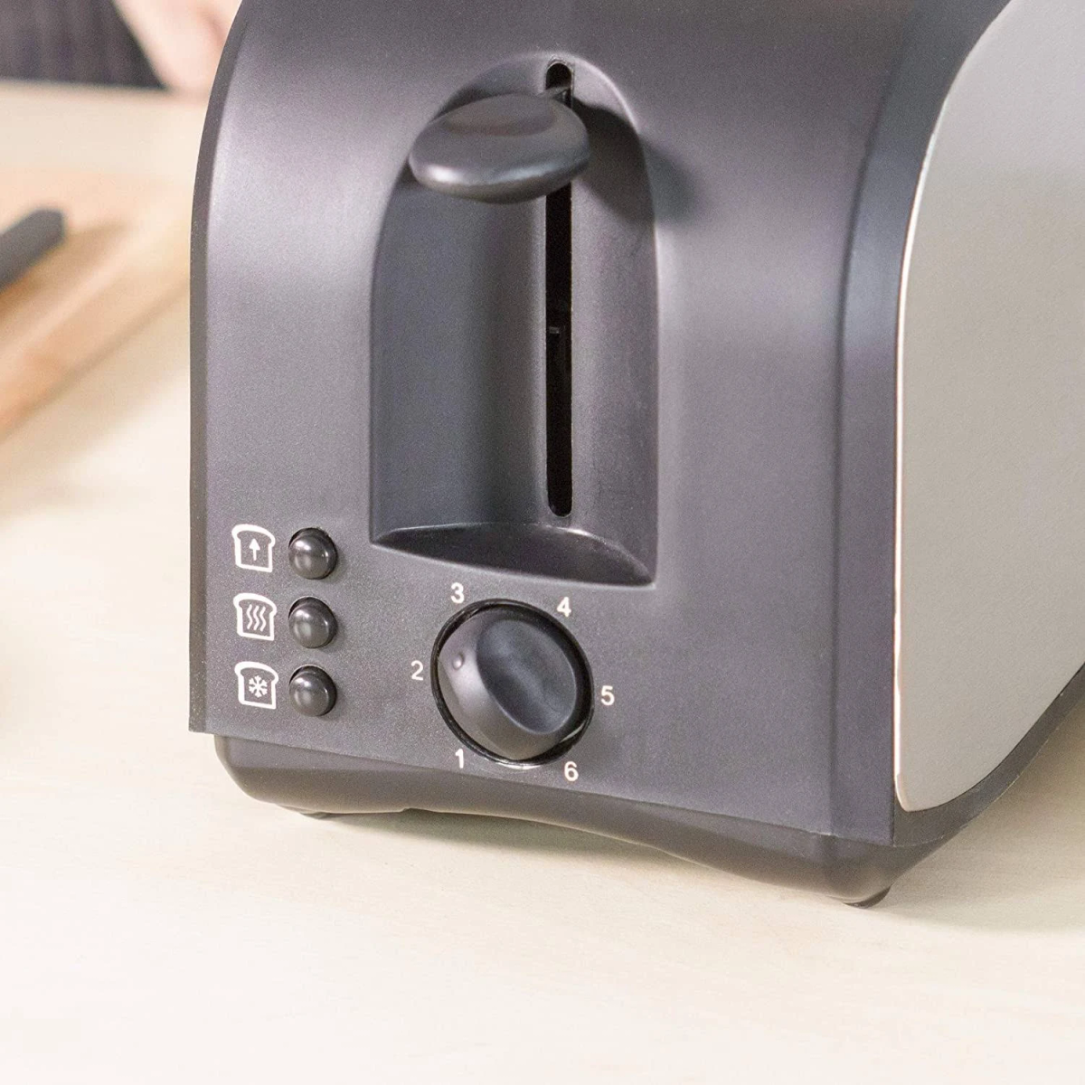 Czarny i szary toster, z pokrętłem i przyciskami do różnych opcji opiekania.