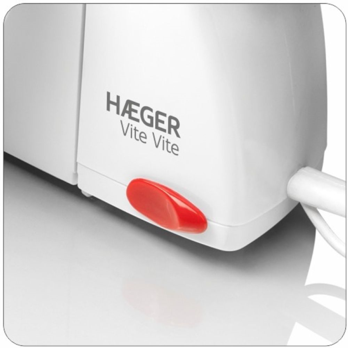Primer plano de un electrodoméstico blanco con un botón rojo, la marca es HAEGER.