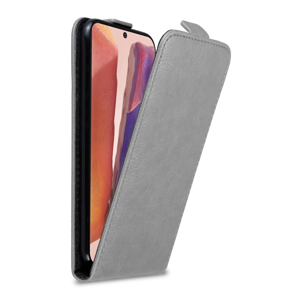 Una custodia grigia per telefono, aperta per rivelare uno smartphone nero con schermo rosa e viola.