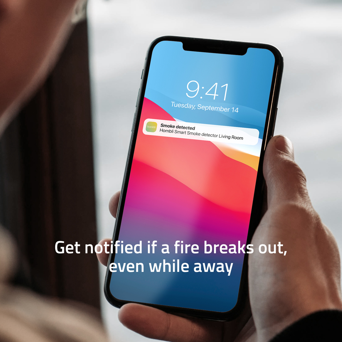 Hand, die ein Telefon hält, das eine Raucherkennung anzeigt. Der Hintergrund ist verschwommen.