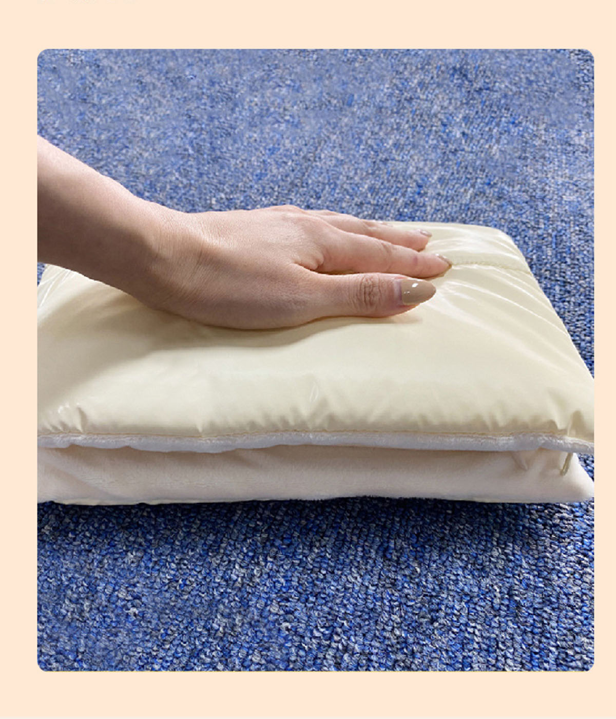 Hand auf einem cremefarbenen Kissen auf blauem Teppich.
