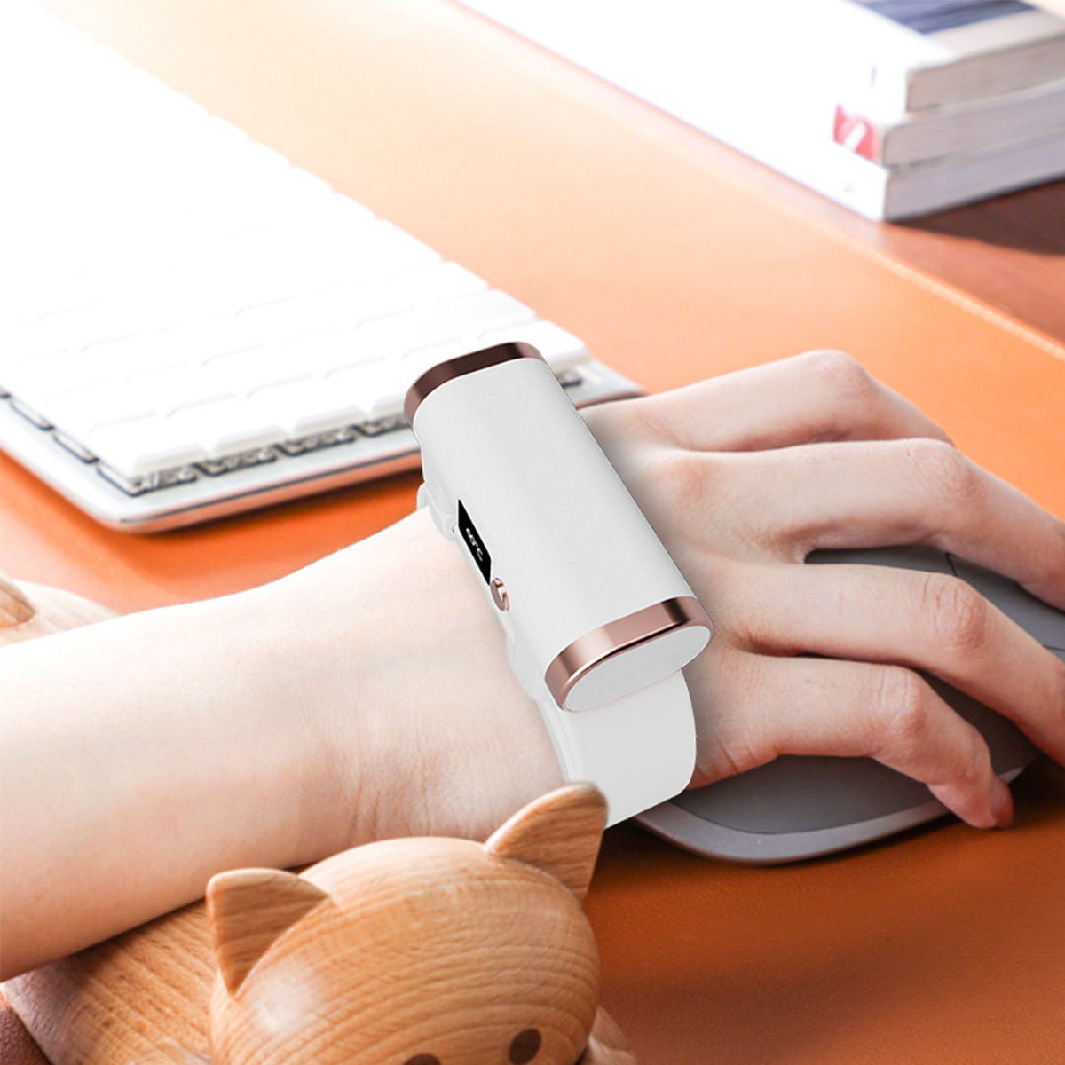 Das Handgelenk einer Person mit einem weißen und roségoldenen Smart-Armband.