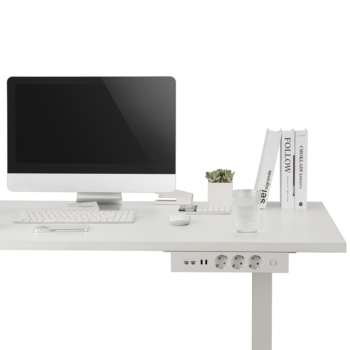 Weißer Schreibtisch mit Computer, Büchern und Steckdose. Pflanzen, Tastatur und Maus sind sichtbar.