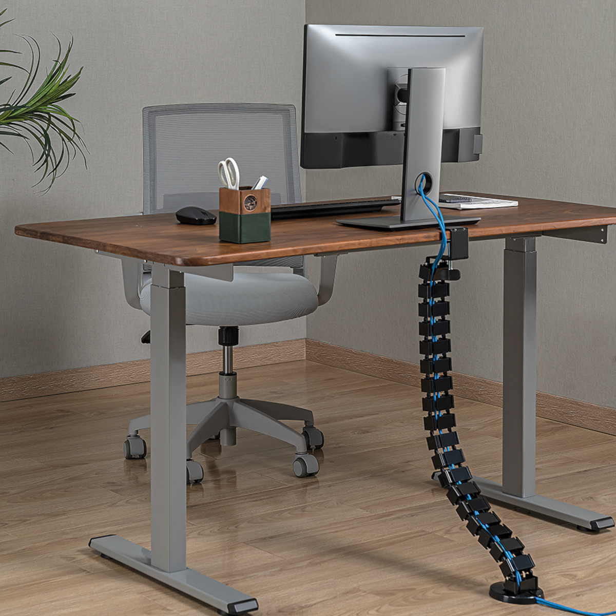 Schreibtisch-Setup mit Monitor, Kabelmanagement, Stuhl und Büromaterial. Moderner Arbeitsplatz.