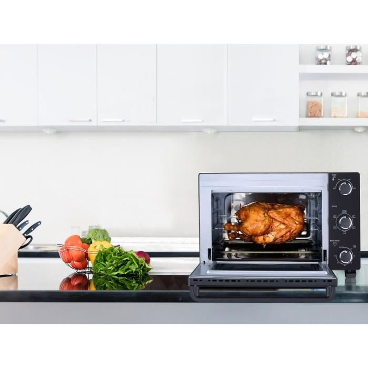 Horno con pollo asado dentro, sobre una encimera con verduras, en un entorno de cocina.