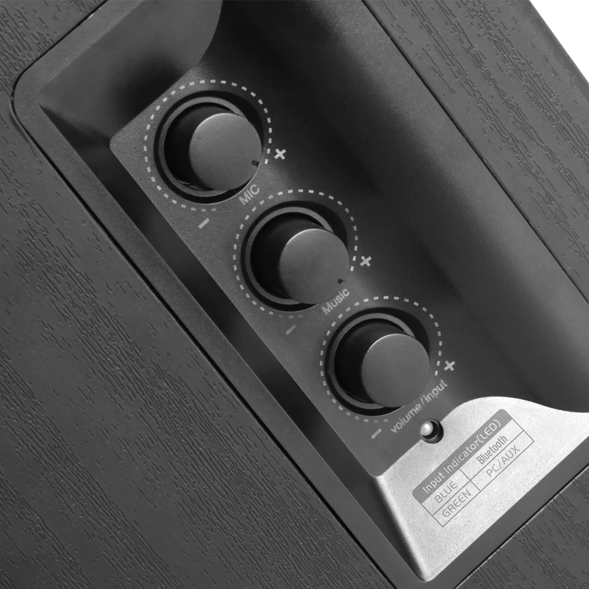 Zbliżenie panelu sterowania głośnikiem. Istnieją trzy pokrętła oznaczone Mic, Music i Volume/Input.