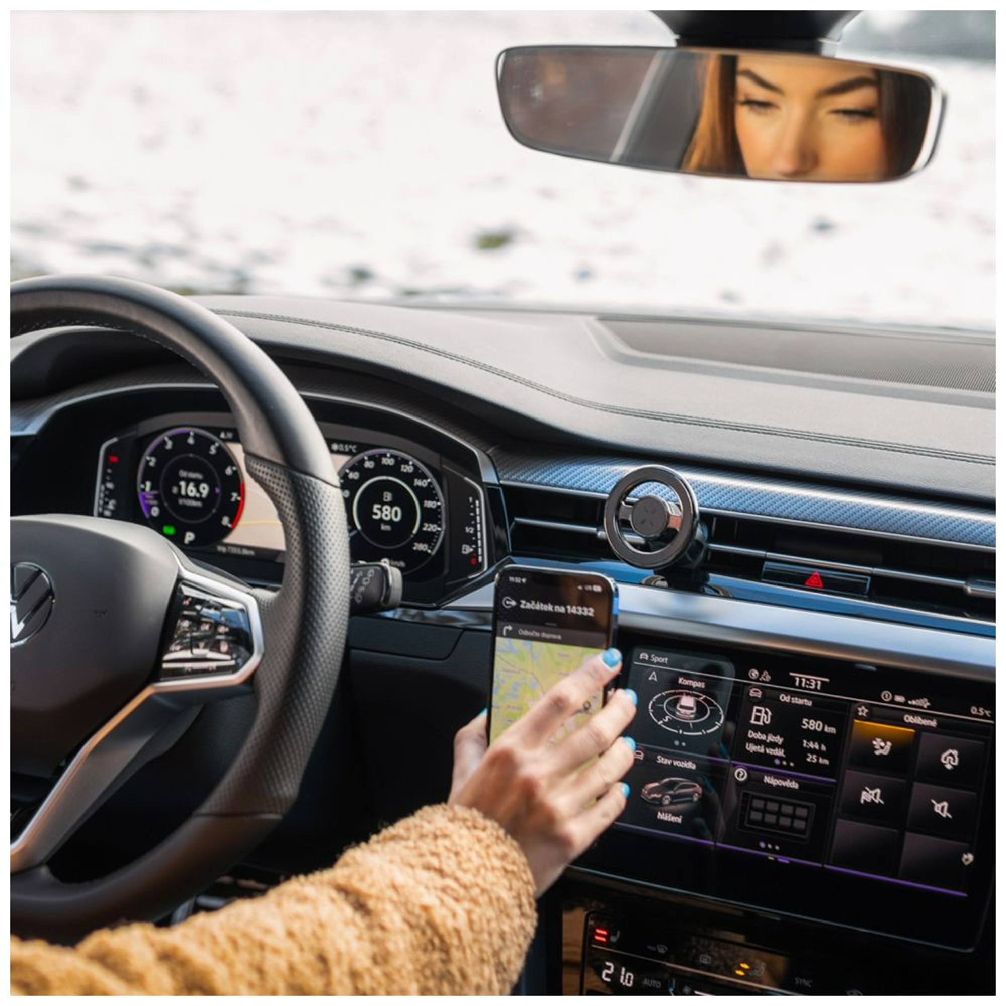 Frau benutzt ein Telefon, das in einem Auto montiert ist. Der Innenraum des Autos ist sichtbar.