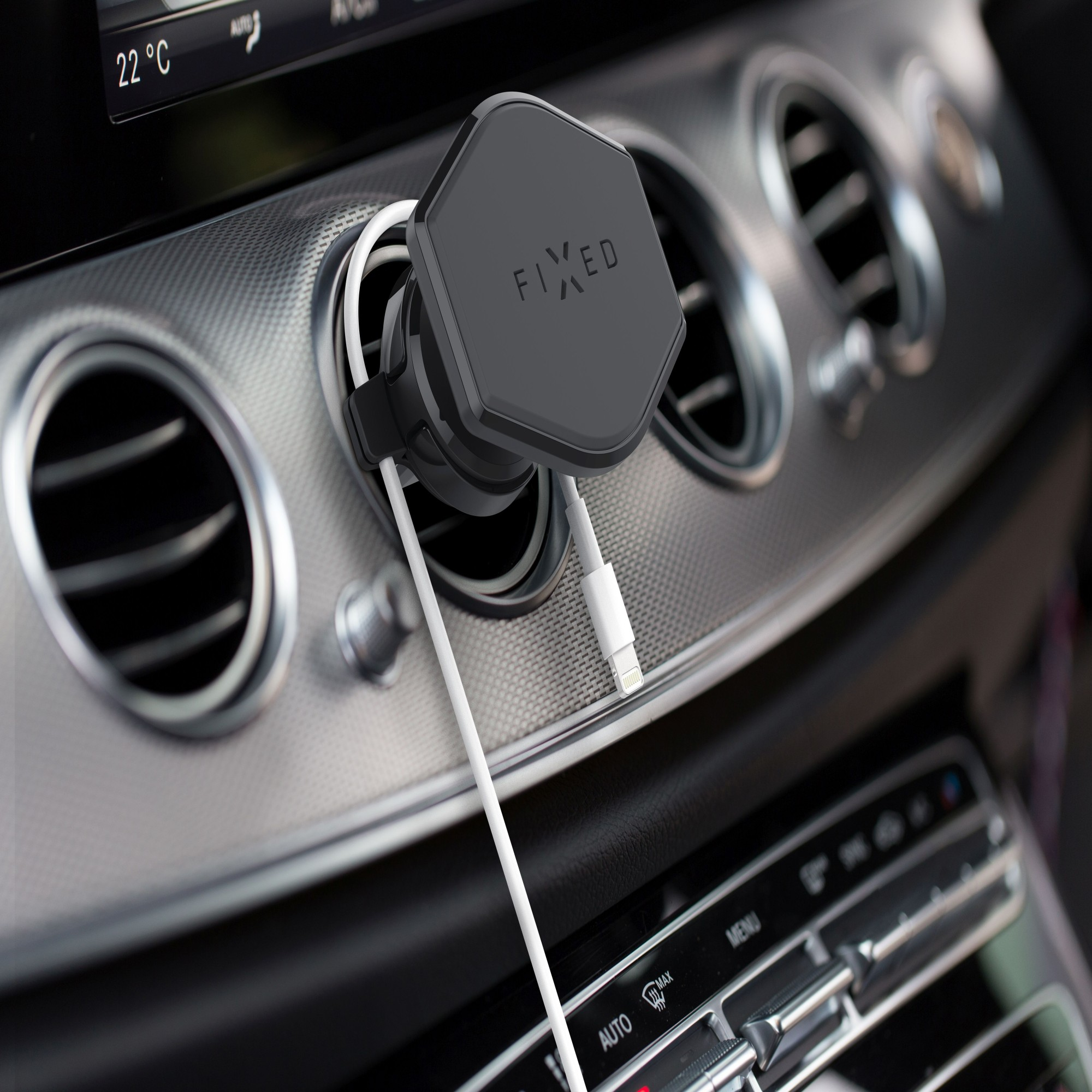 Eine Autolüfterhalterung mit befestigtem Telefon, weißem Kabel, im Fahrzeuginnenraum.