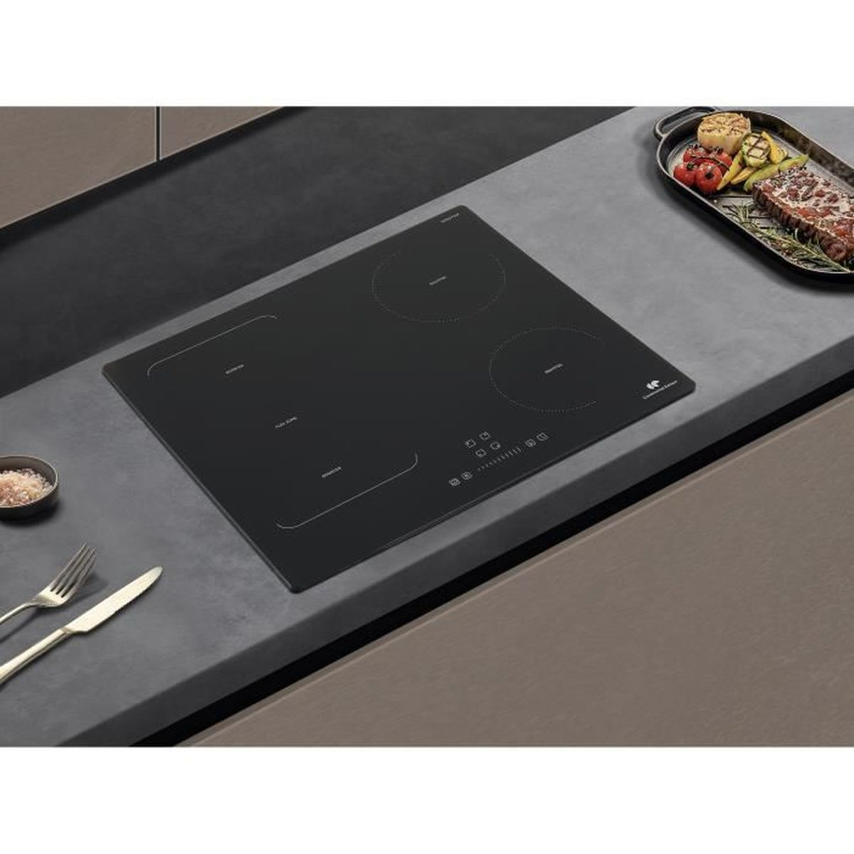 Czarna płyta indukcyjna na blacie, z czterema strefami gotowania. Taca z jedzeniem po prawej.
