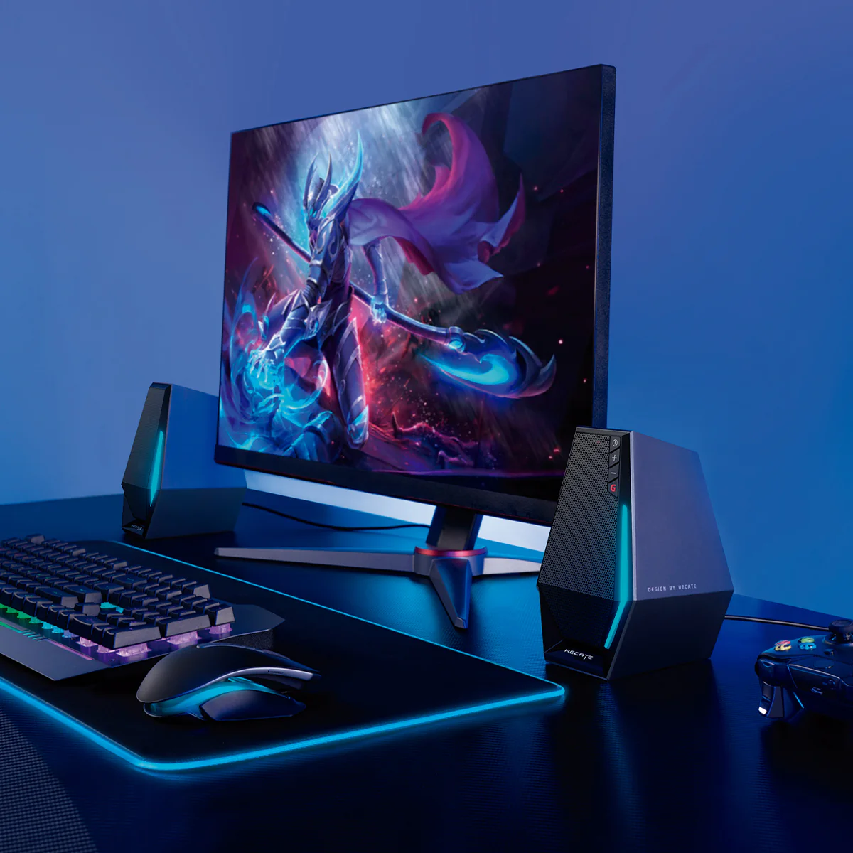 Gaming-Setup: Monitor mit Fantasy-Kunst, Lautsprecher, Tastatur, Maus und Controller.