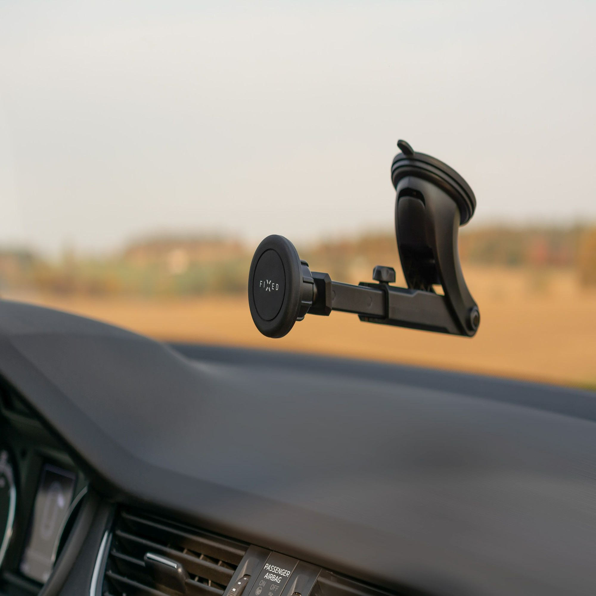 Eine Autotelefonhalterung ist auf dem Armaturenbrett montiert, mit neutralem Hintergrund.