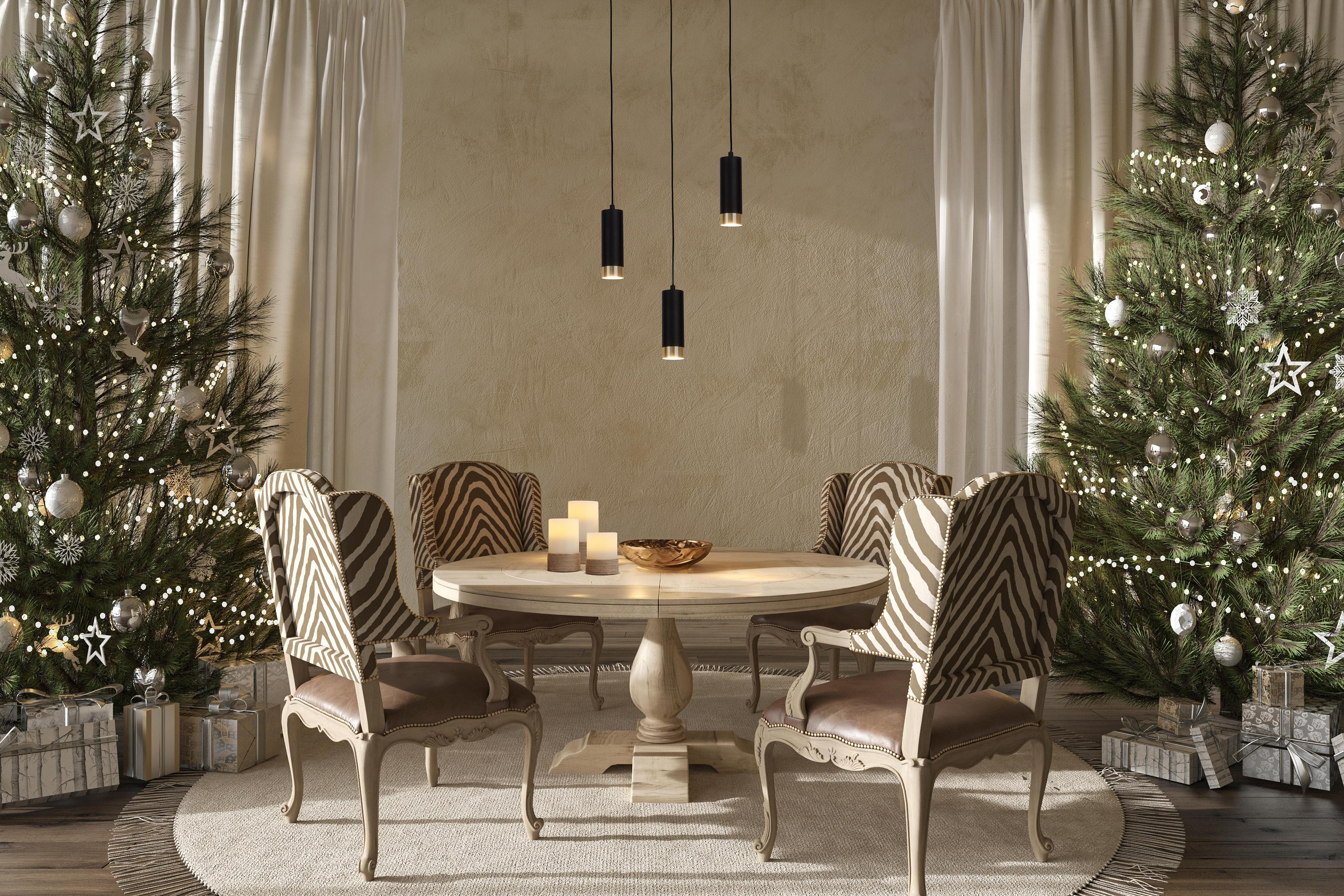 Esszimmer-Setup mit rundem Tisch, Stühlen und zwei Weihnachtsbäumen.