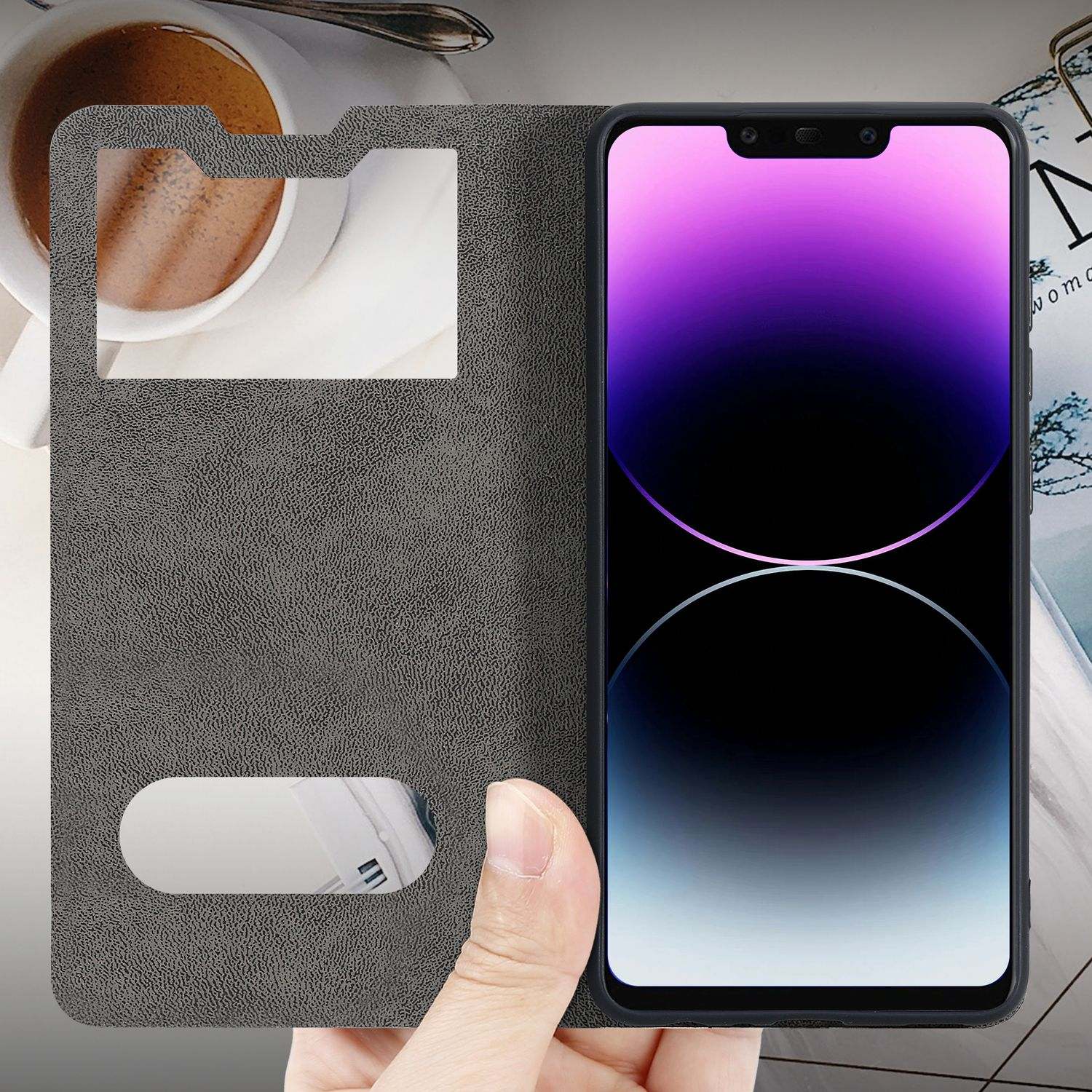 Telefono all'interno di una custodia a libro, parzialmente aperto. Tazza di caffè e rivista sullo sfondo.