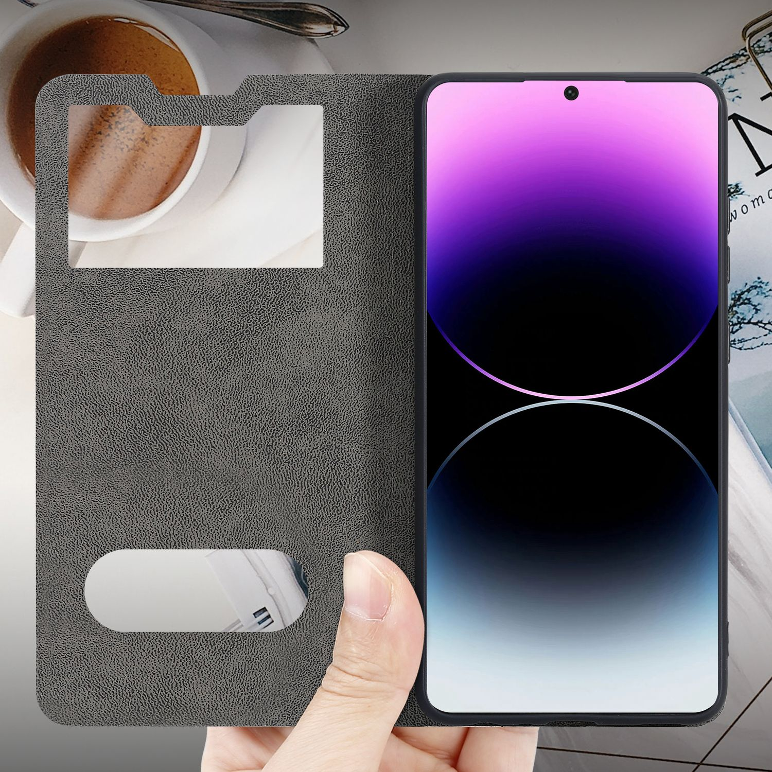 Mano che tiene un telefono con finestra, caffè e rivista visibili.