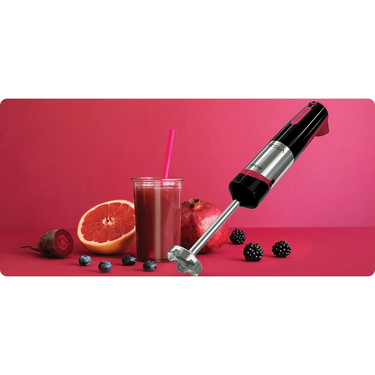 Blender i składniki na czerwonej powierzchni. Zawiera połówkę grejpfruta.