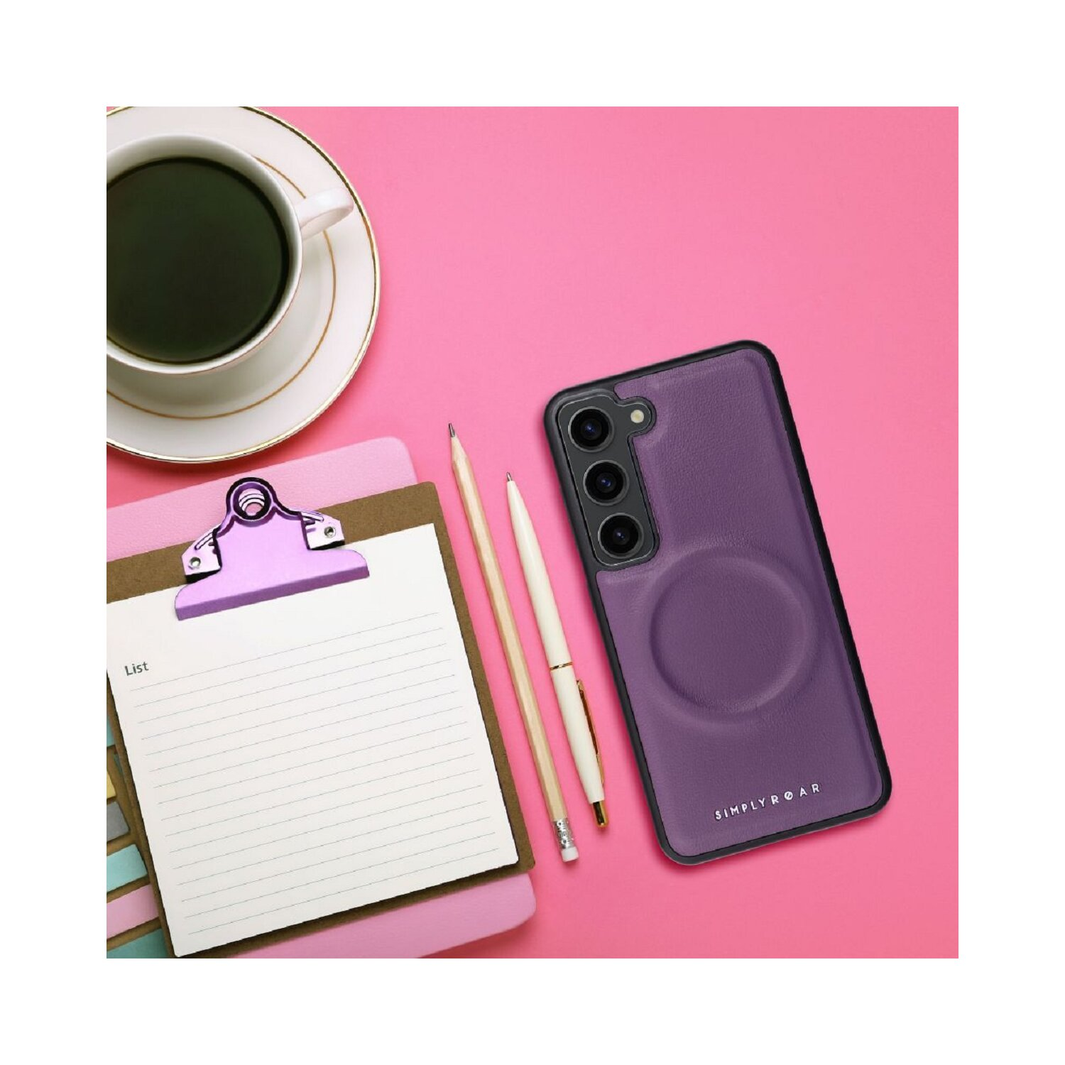 Lila Handyhülle mit Stift, Notizblock und Kaffee. Rosa Hintergrund.