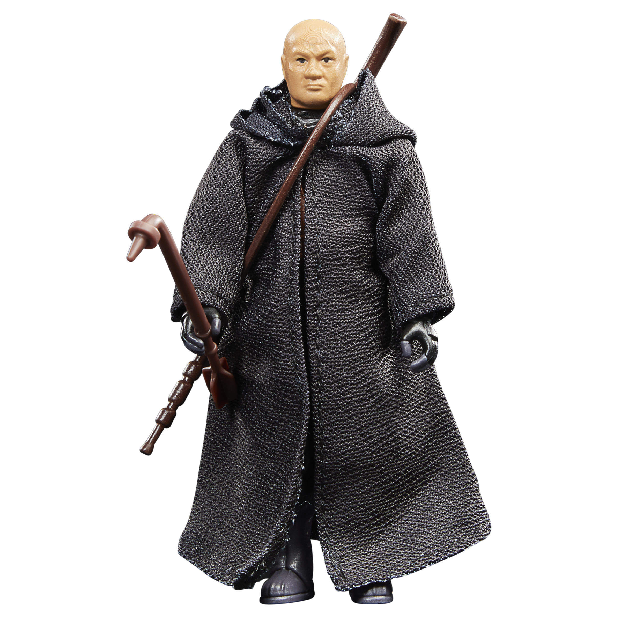 Figura de hombre calvo con túnica negra con capucha, sosteniendo dos bastones marrones.