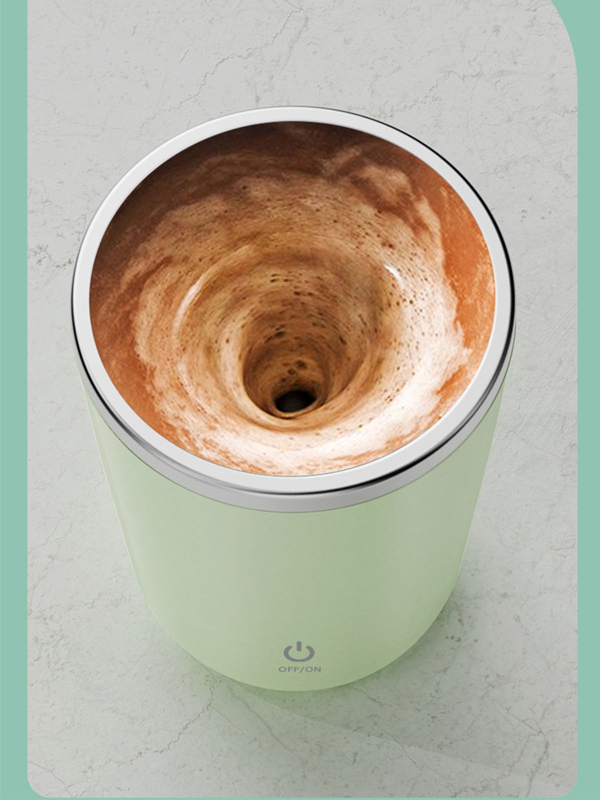 Eine Tasse mit sich drehendem Kaffee. Die Tasse ist mintgrün mit silbernem Rand, Hintergrund ist unscharf.