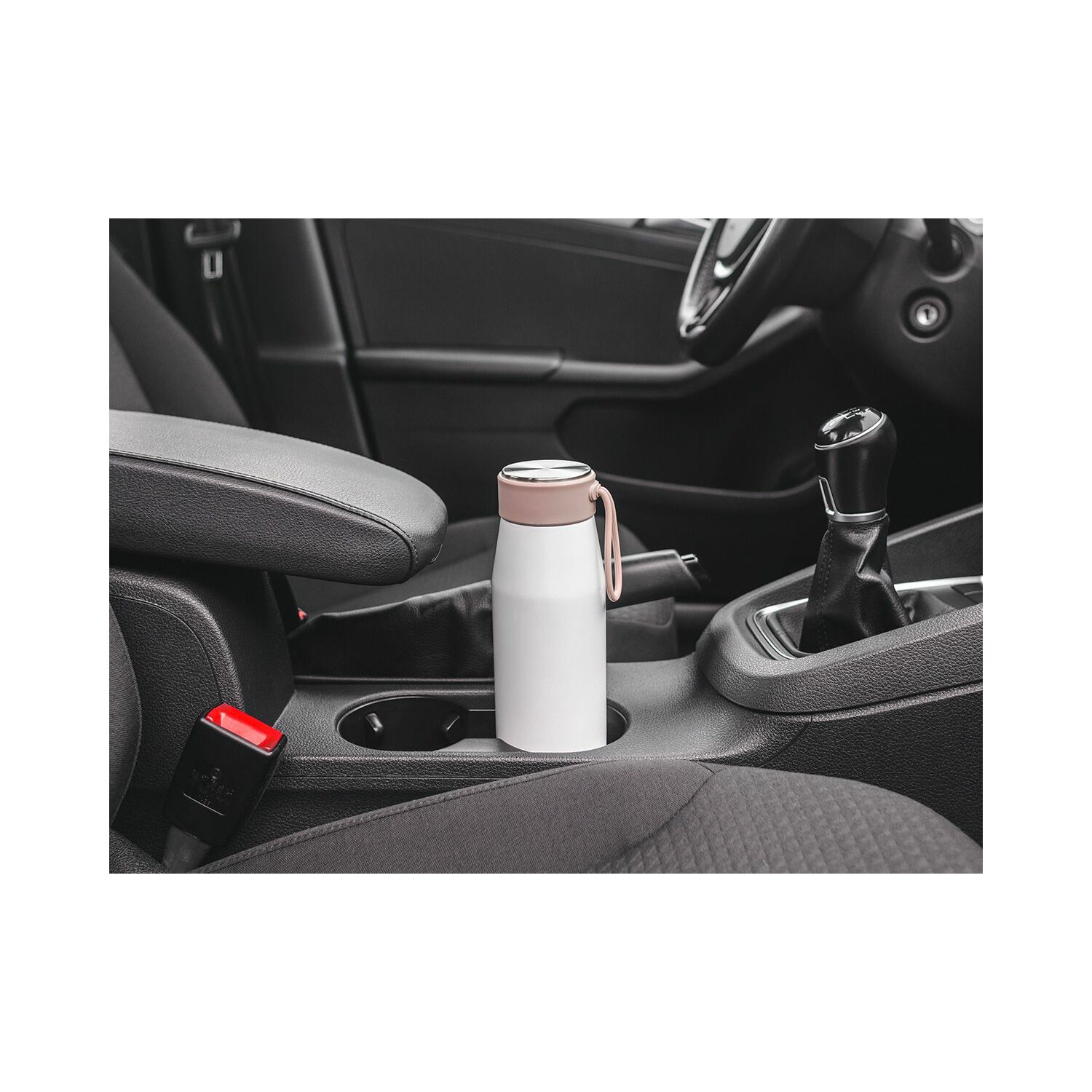 Weiße Wasserflasche im Getränkehalter eines Autos.